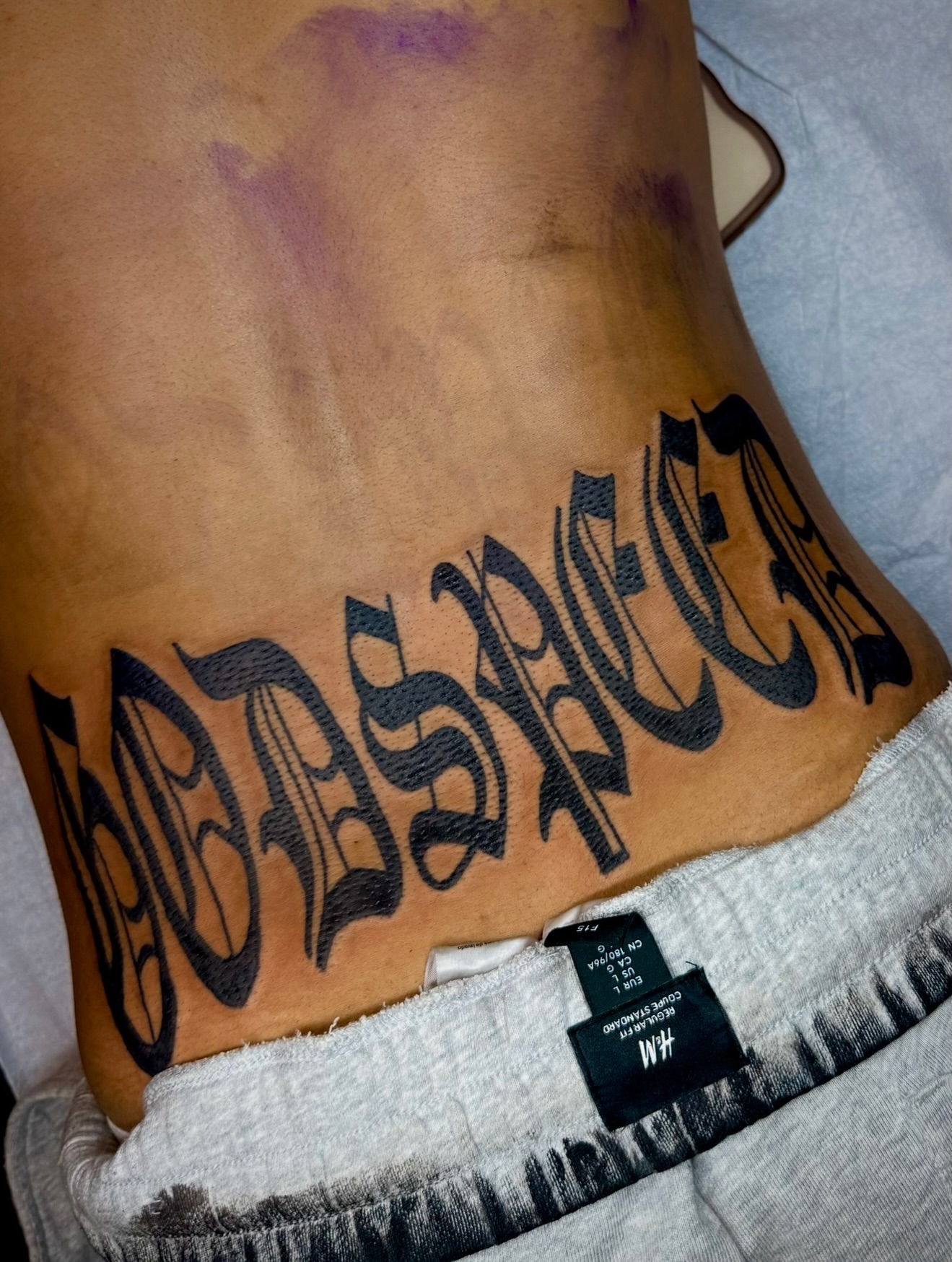 No response lettering script tattoo on the ribs by Zac Clark