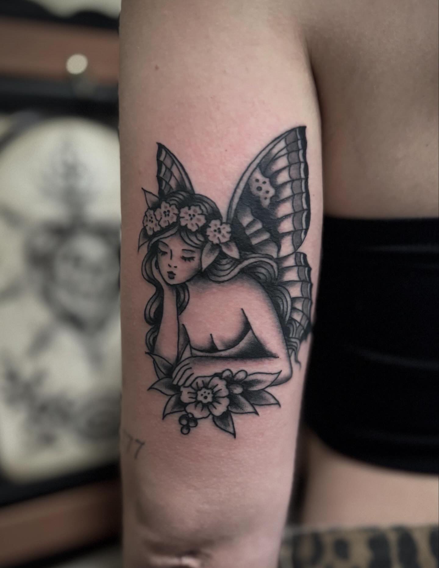 Fairy with flowers black and grey tattoo on the forearm by Micah Norman, San Francisco, California