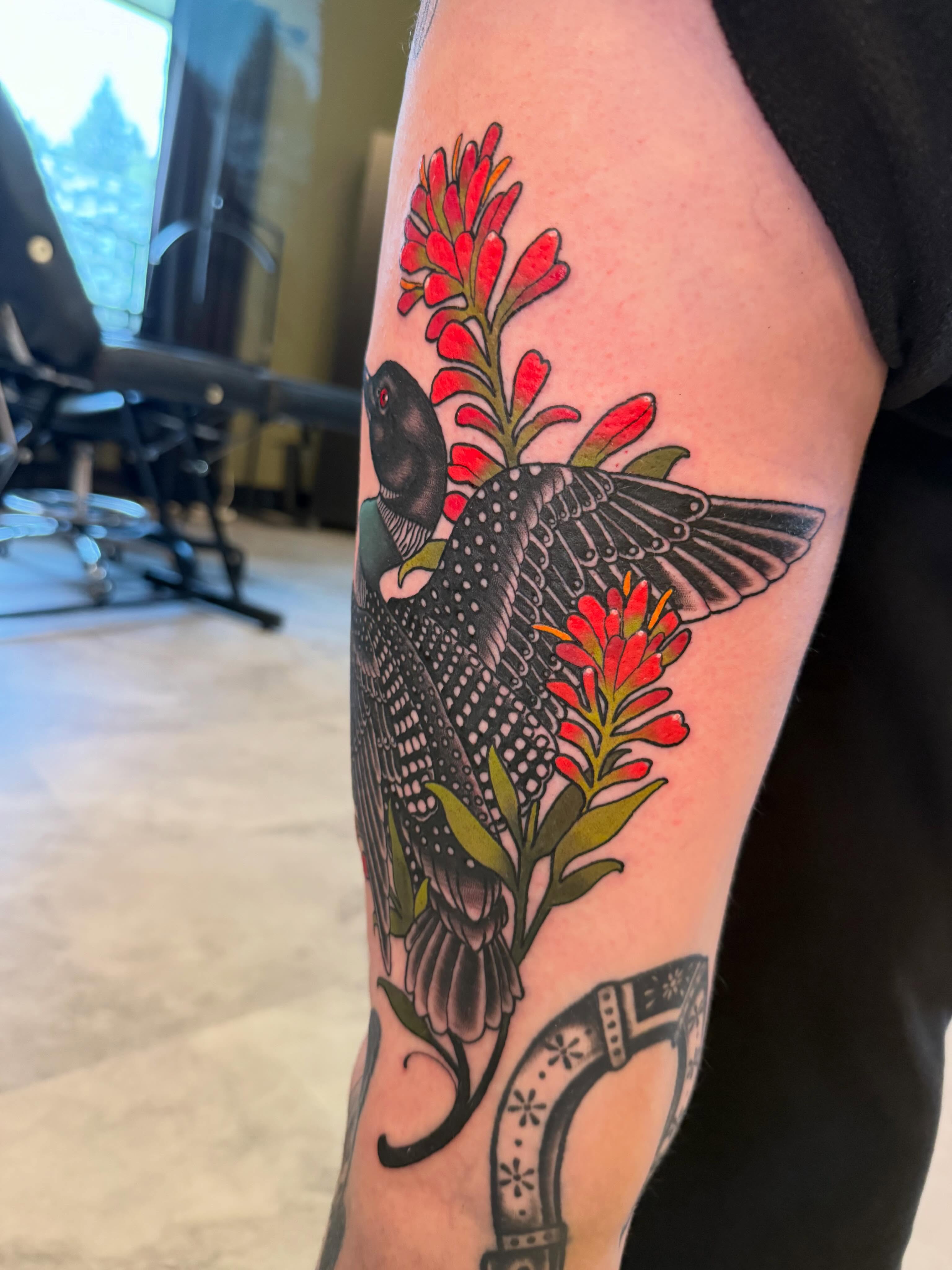 Loon and wildflowers American traditional tattoo on the forearm by Kyle Behr