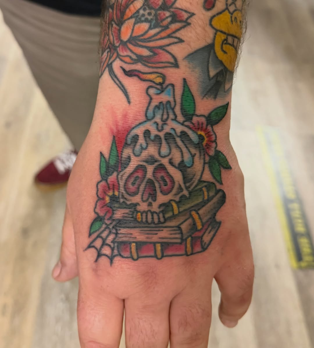 Skull and books American traditional tattoo on the hand by Kane L, Albuquerque, New Mexico