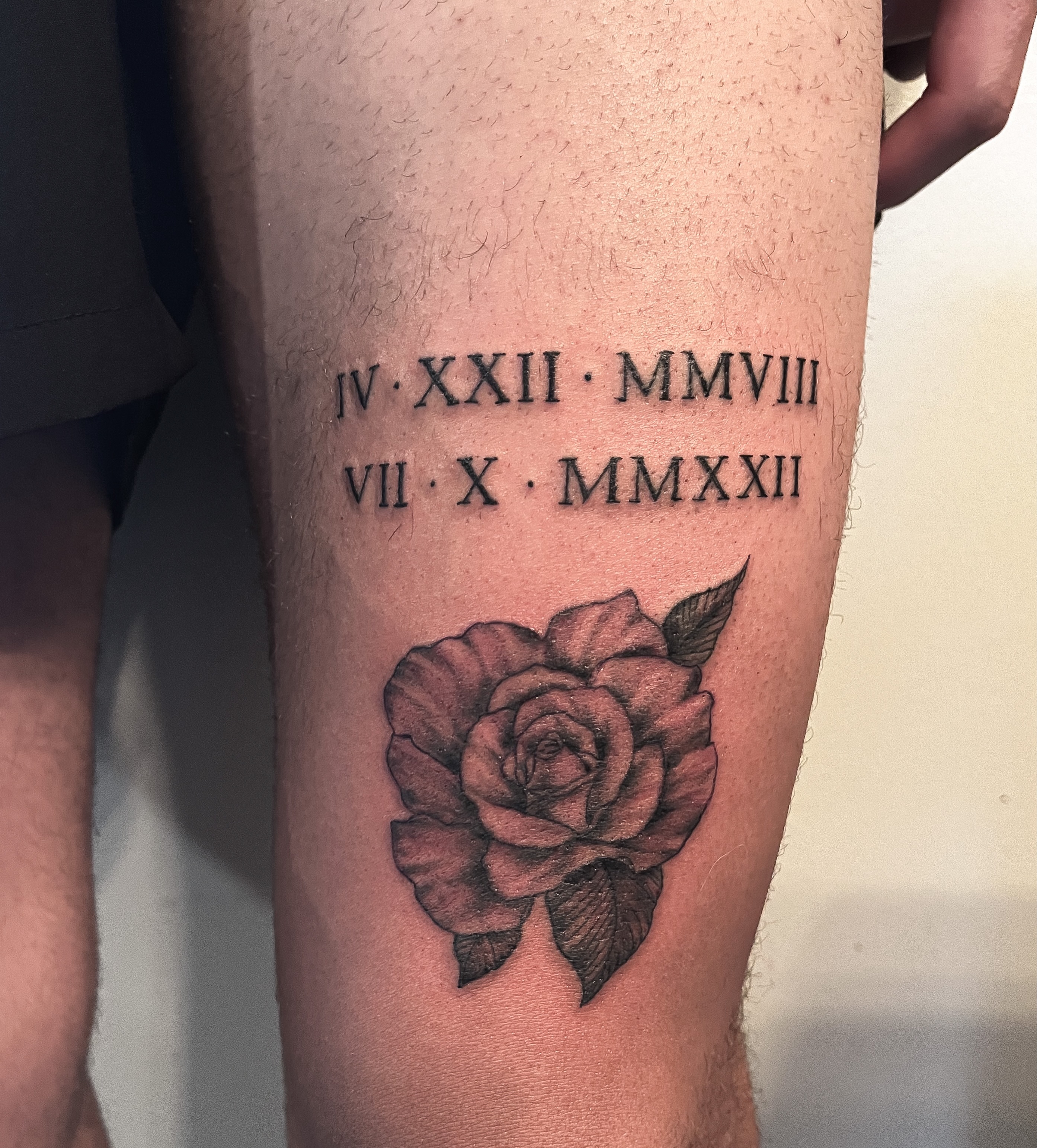 Roman numerals and rose black and grey tattoo on the thigh by Janelle Cuba