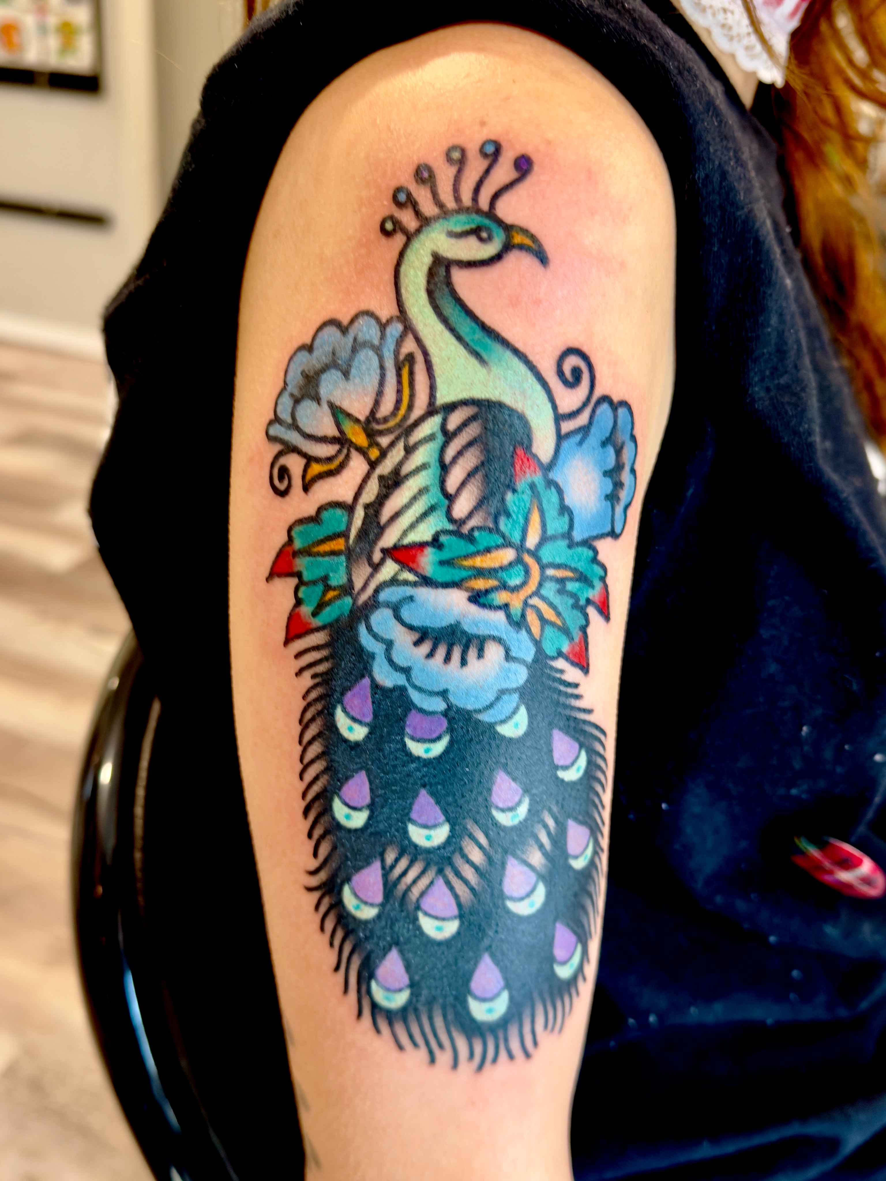 Peacock American traditional tattoo on the shoulder by Jimmy Kelley