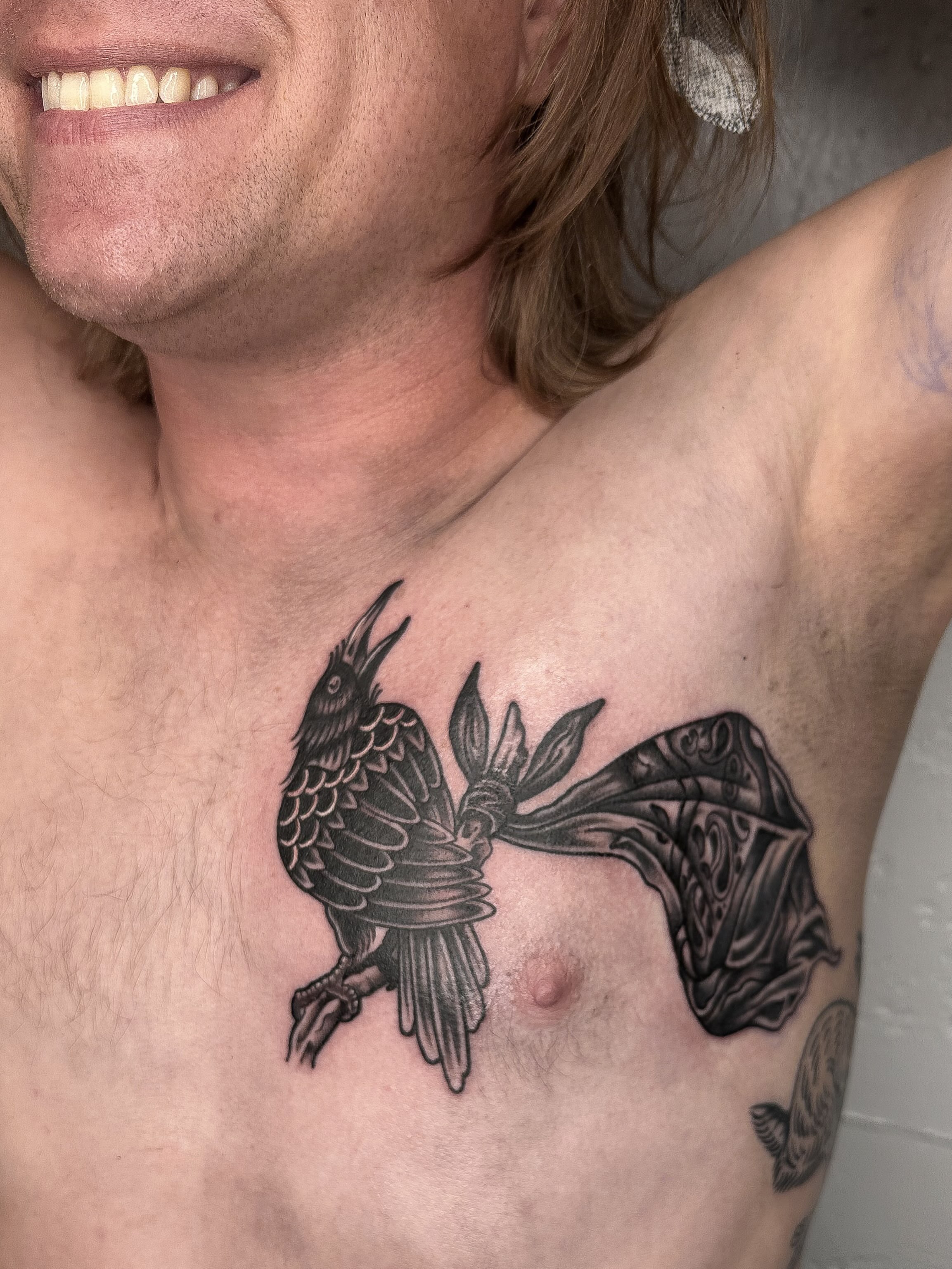 Crow and fish black and grey tattoo on the chest by mia palau