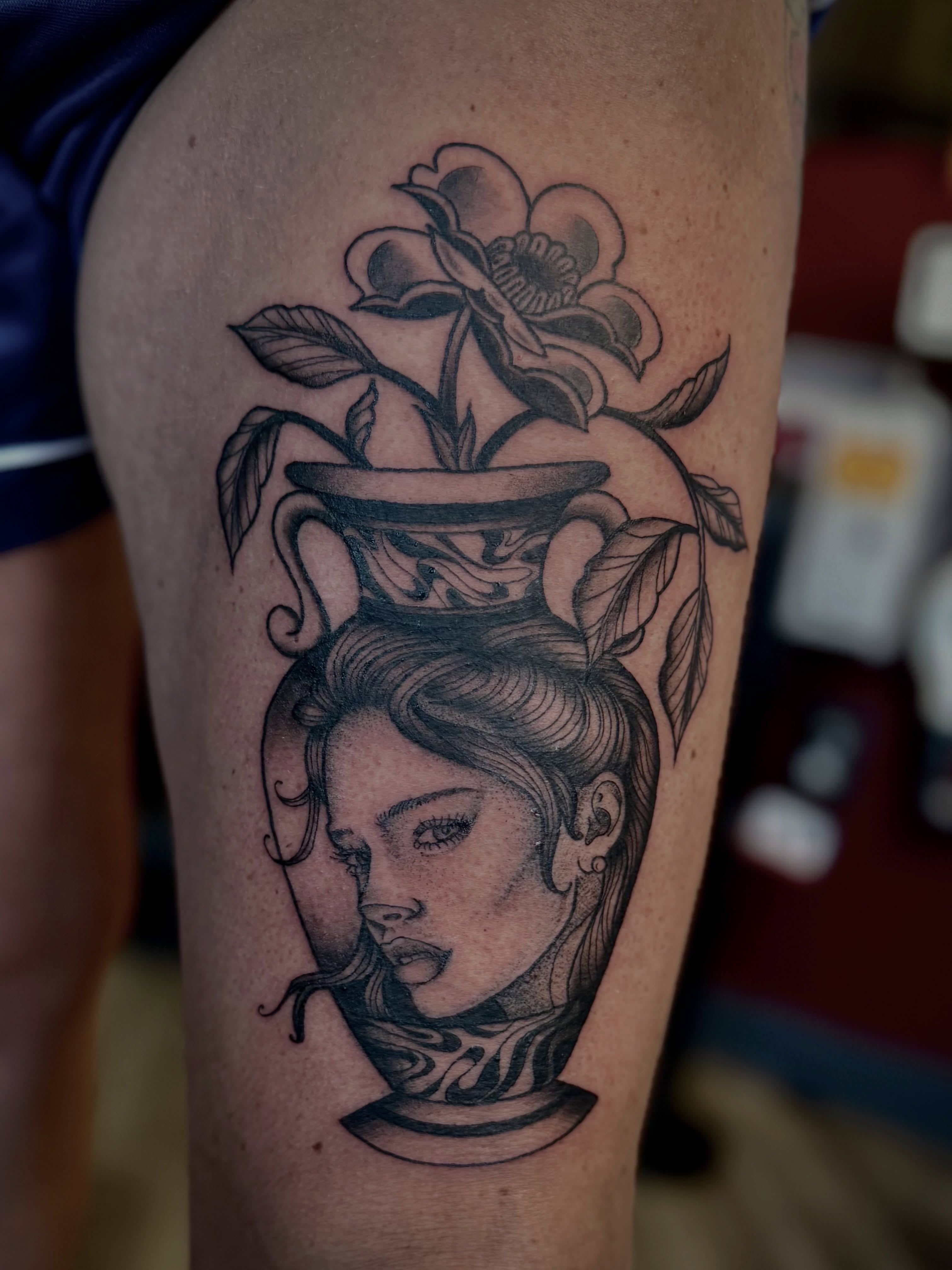 Woman's head with flower pot American traditional tattoo on the thigh by Stevie Reign