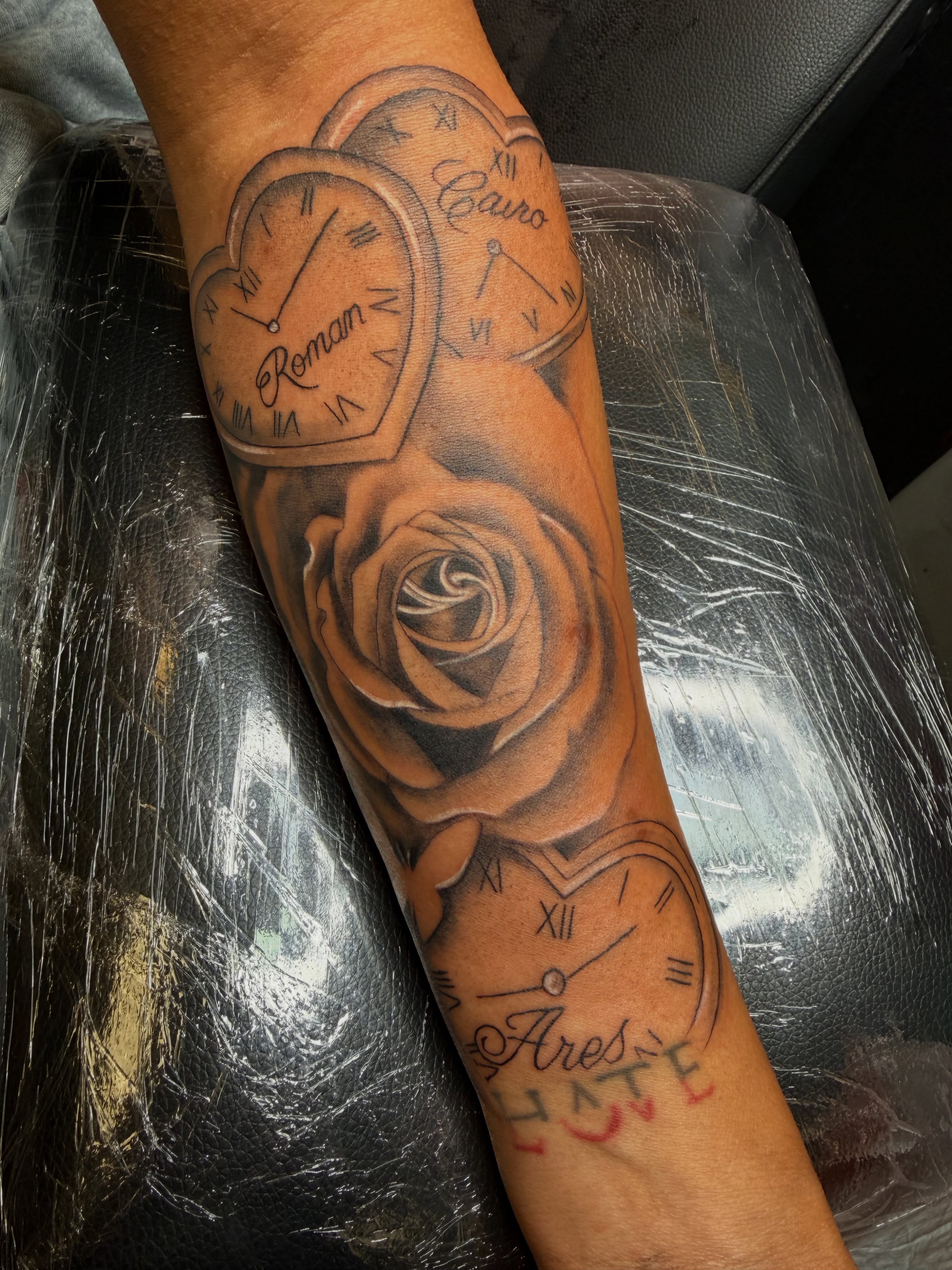 Clocks and roses realism tattoo on the forearm by Rain David