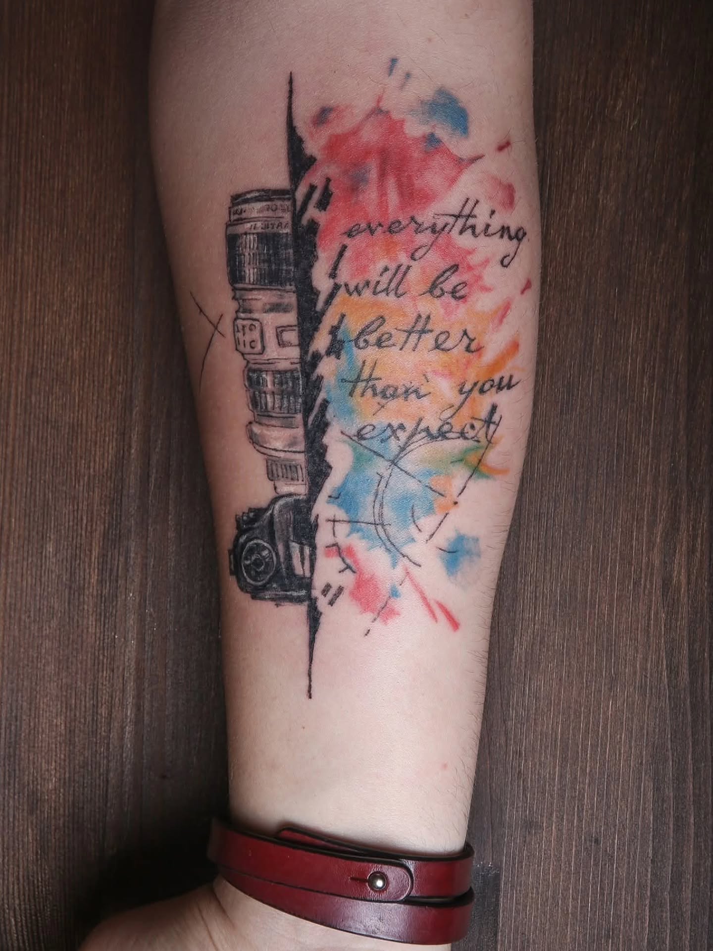 Camera and quote watercolor tattoo on the forearm by Dr. Valerio Vegas Tattoo