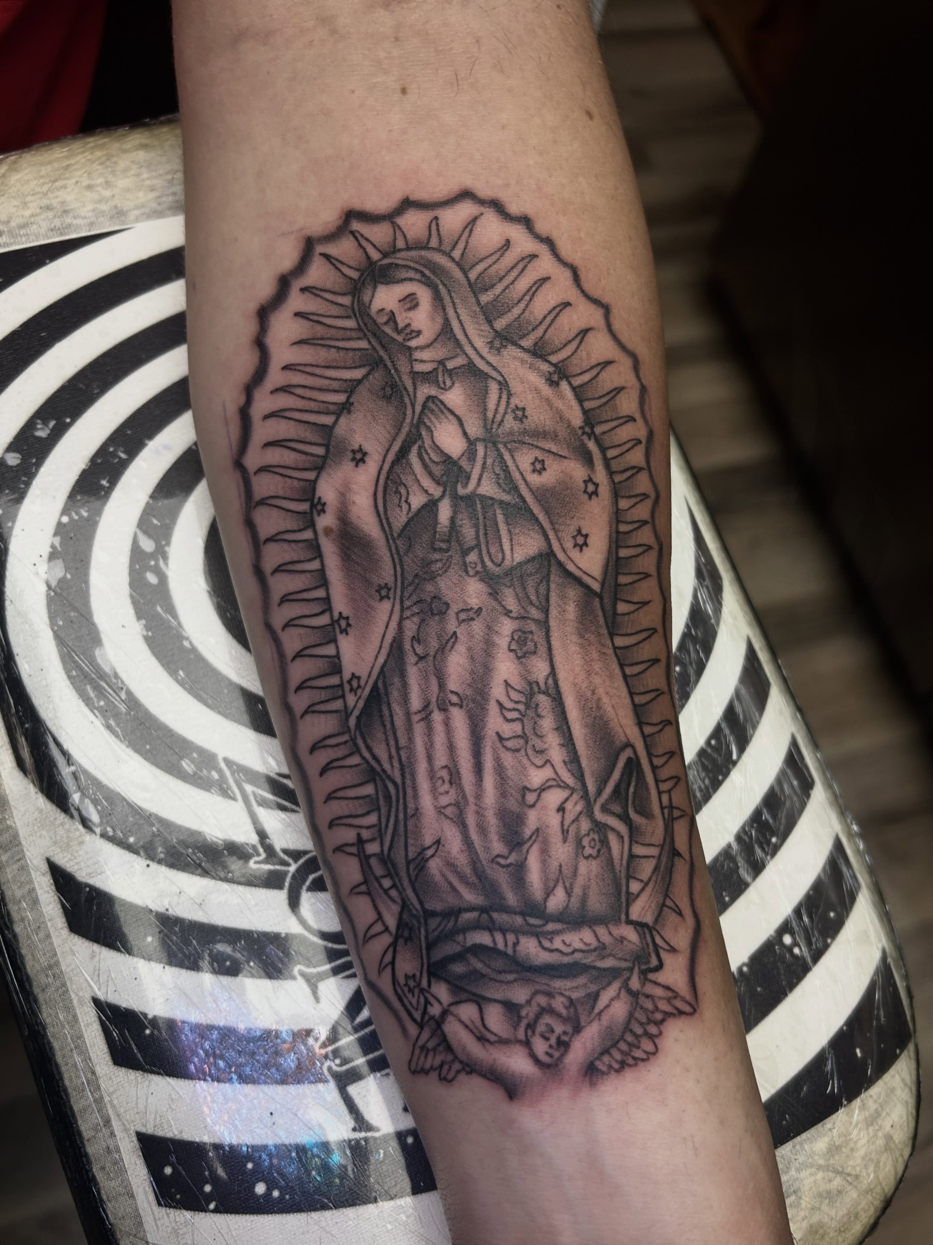 Virgin mary black and grey tattoo on the forearm by Dan Schuster