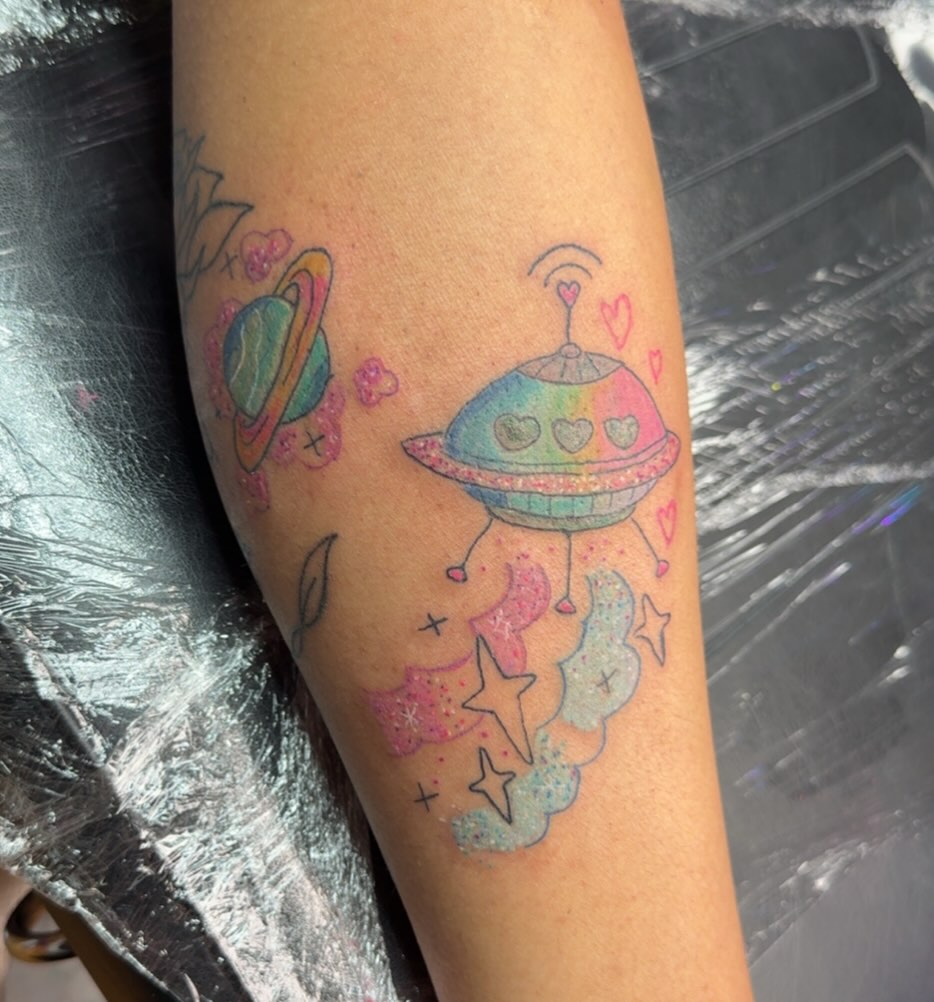 Space-themed UFO new school tattoo on the forearm by Felicia Lee, Des Moines, Iowa