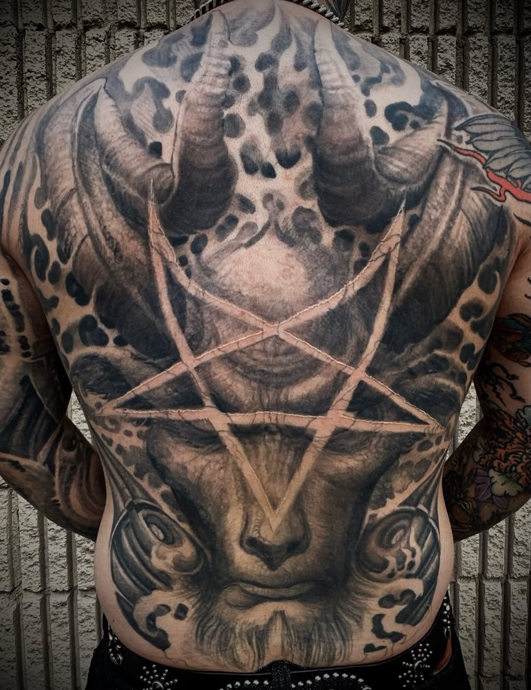 Demonic face with pentagram realism tattoo on the chest by Paul Booth