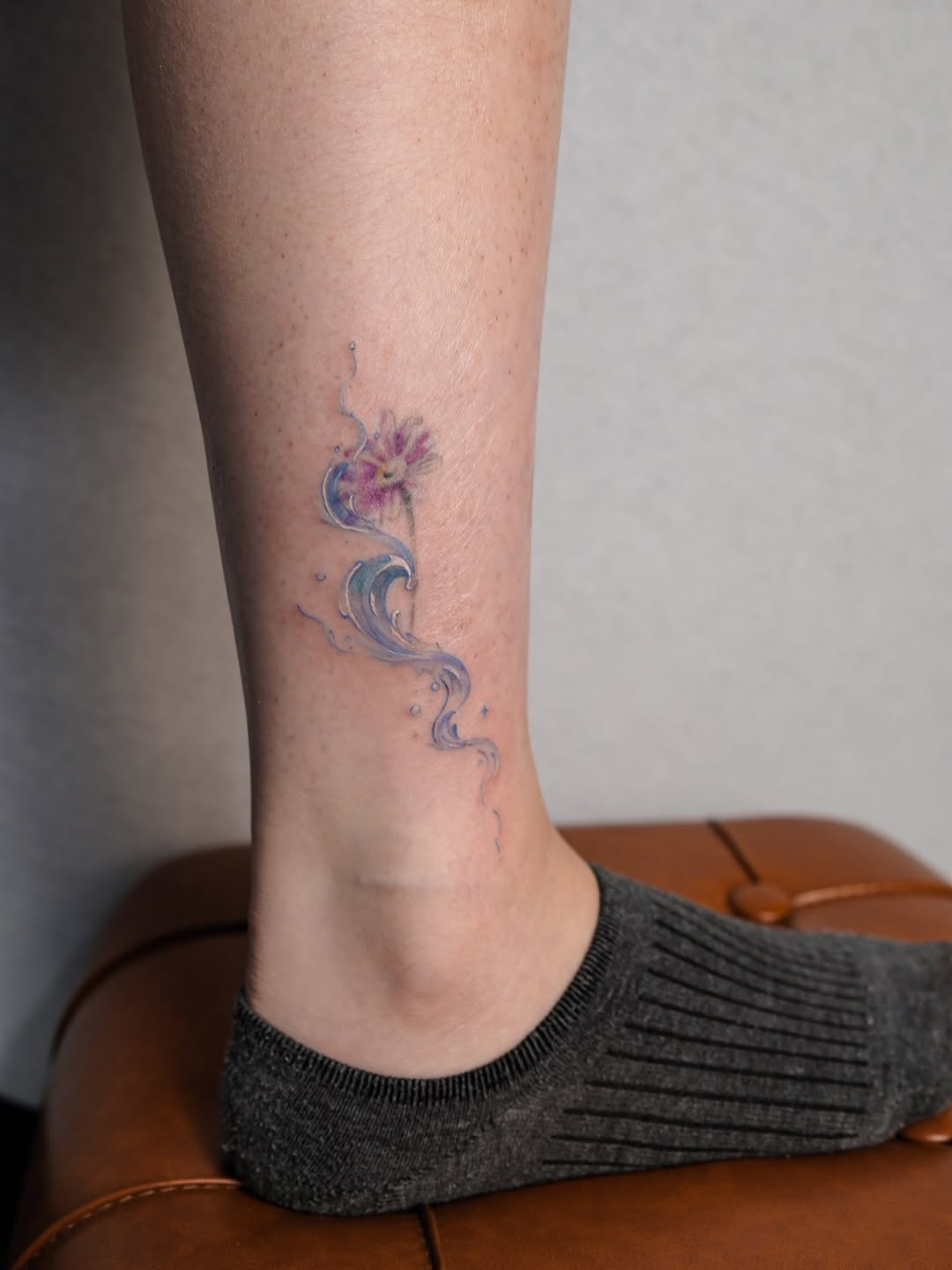 Flower and water watercolor tattoo on the calf by Jinz