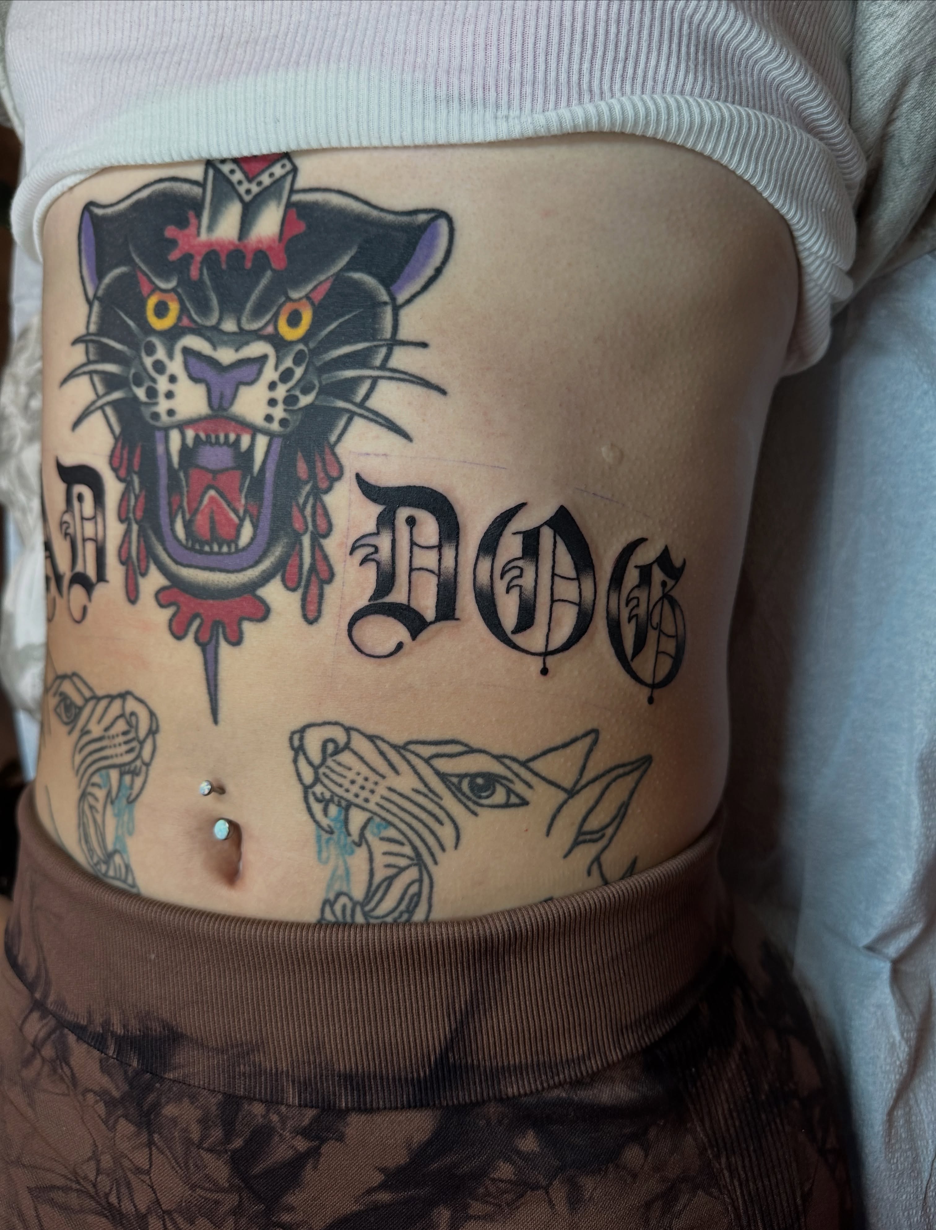 Panther and lettering American traditional tattoo on the torso by Emily Masa
