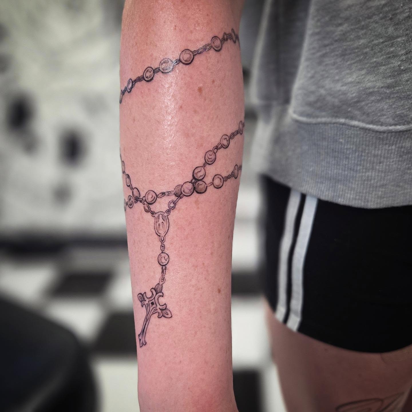Rosary black and grey tattoo on the forearm by Molly DeSmedt
