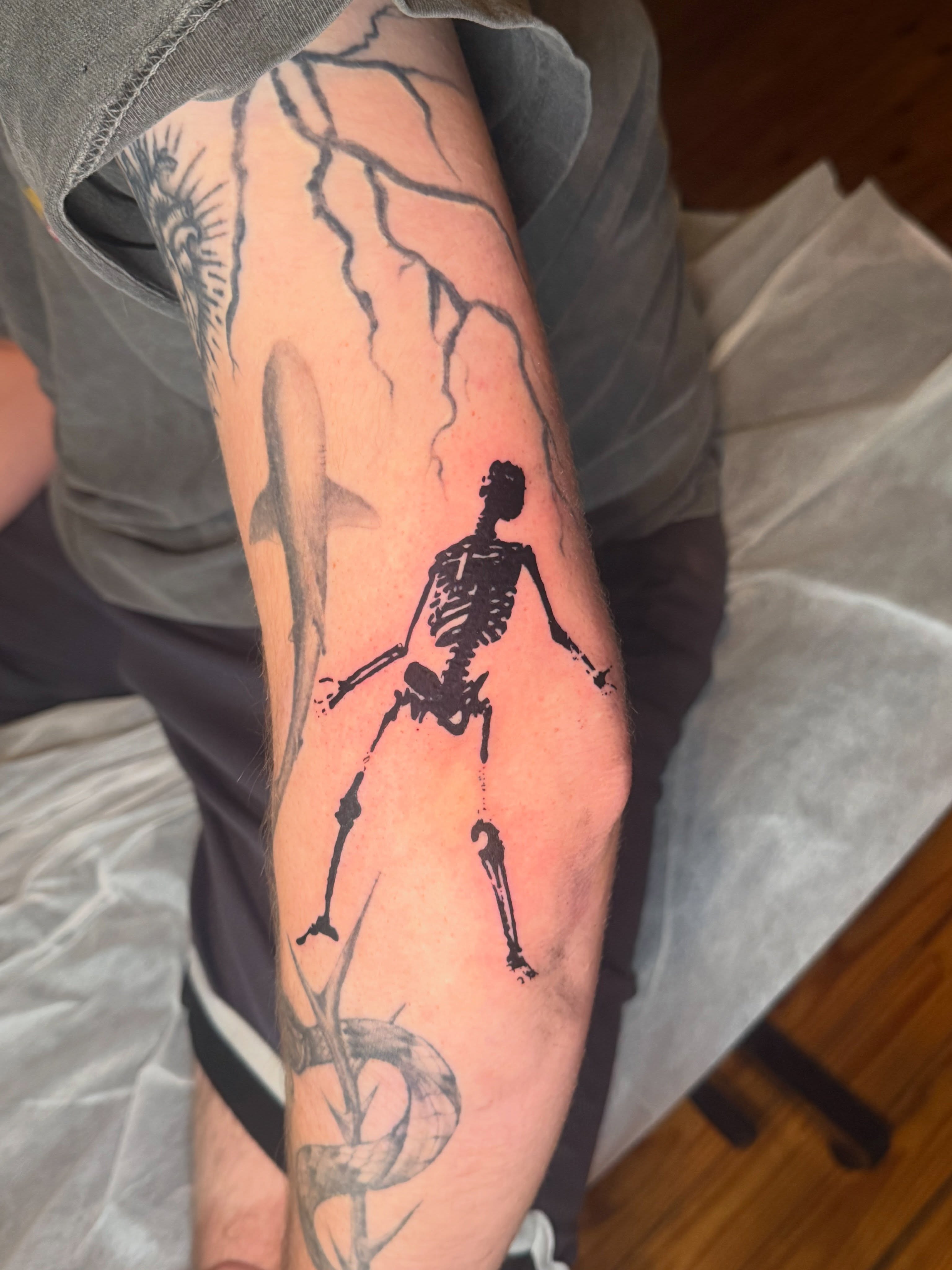 Skeleton with lightning black and grey tattoo on the forearm by Jose Javier