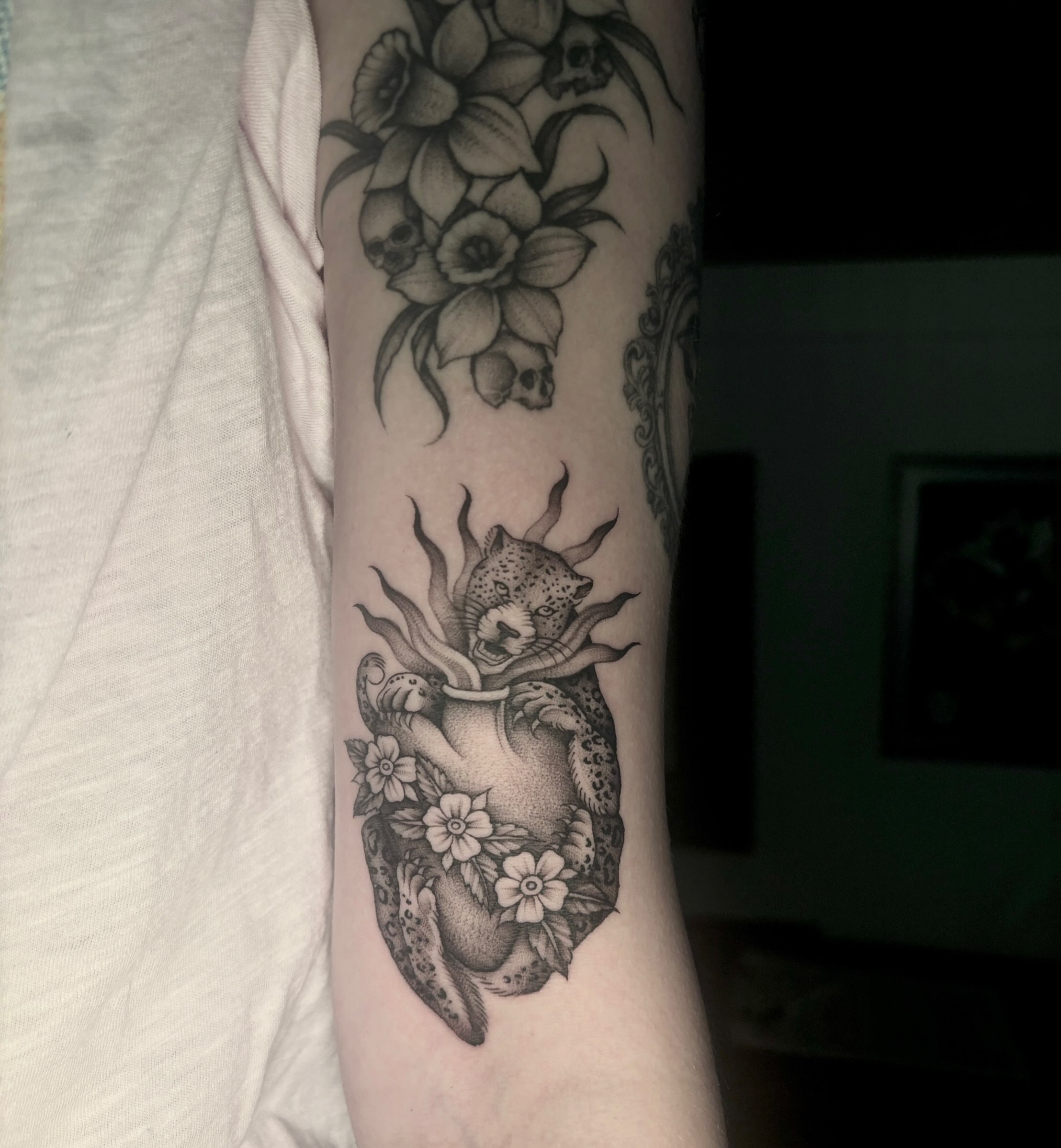 Heart with jaguar realism tattoo on the forearm by Emma Cotter