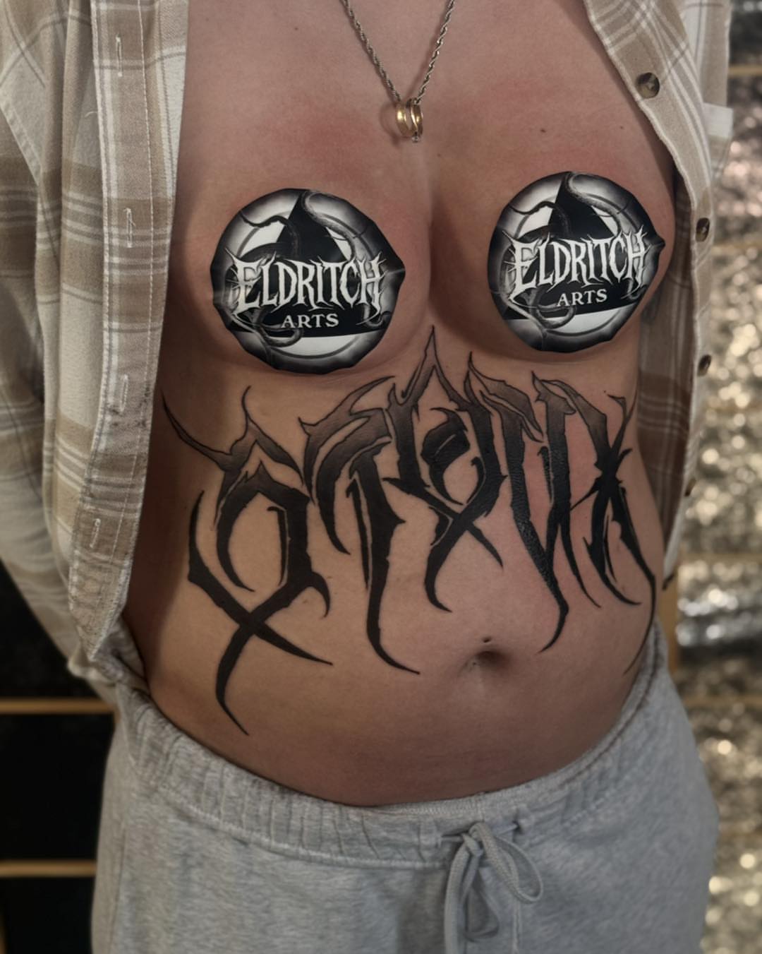 Gothic script black and grey tattoo on the torso by Miles Haysmith