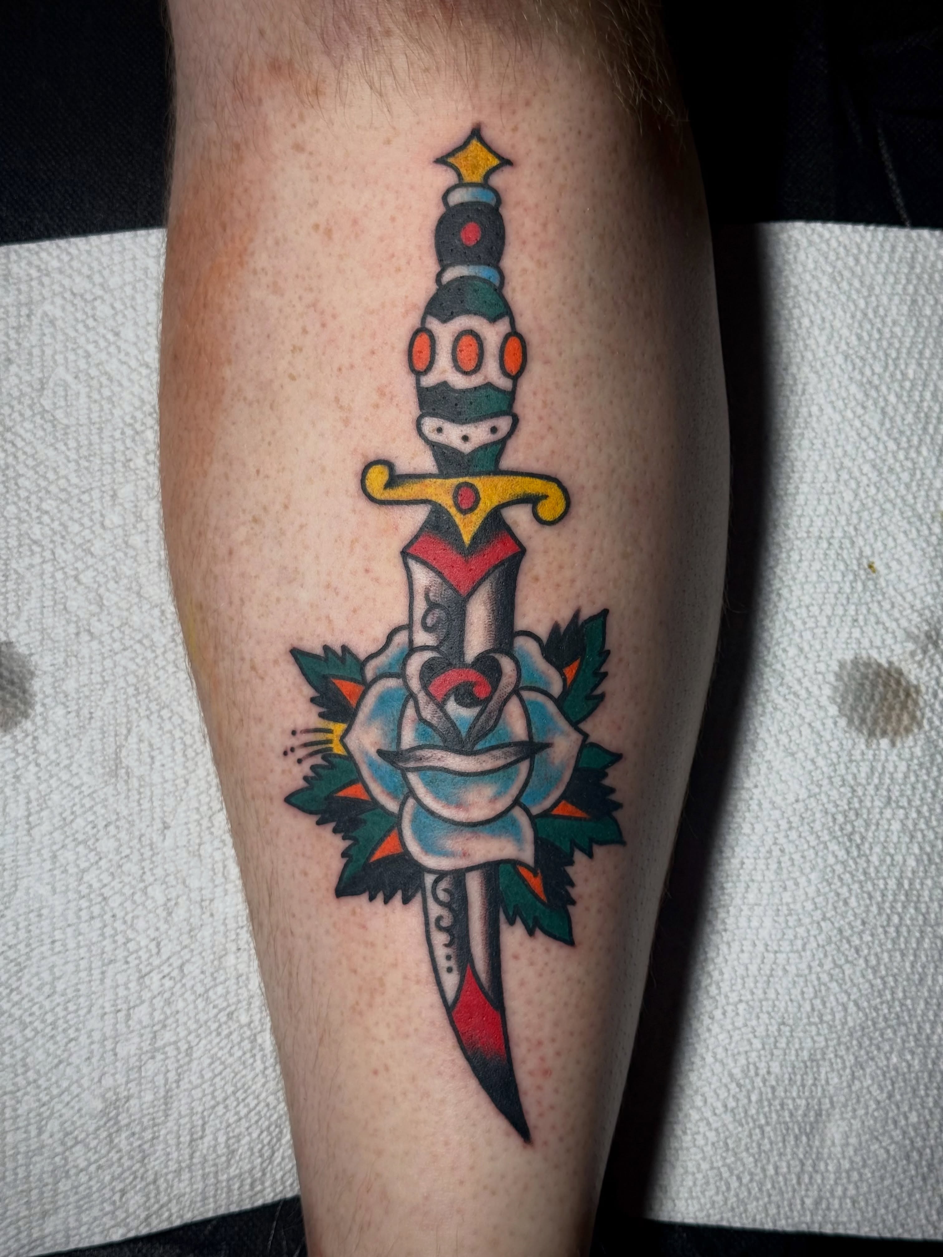 Sword and rose American traditional tattoo on the forearm by Chuck Derek Whitaker