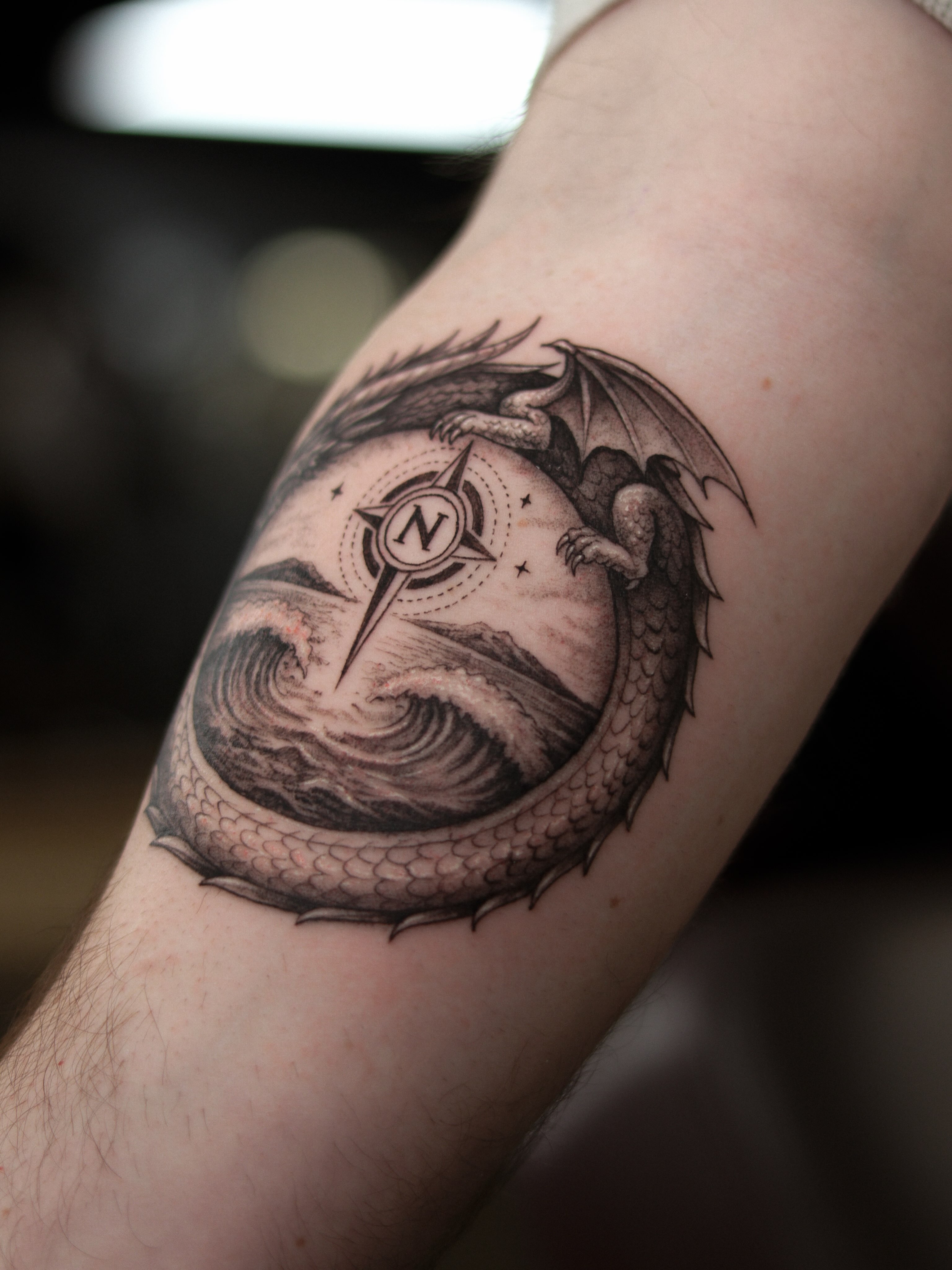 Dragon and compass realism tattoo on the forearm by Arthur Kossoski