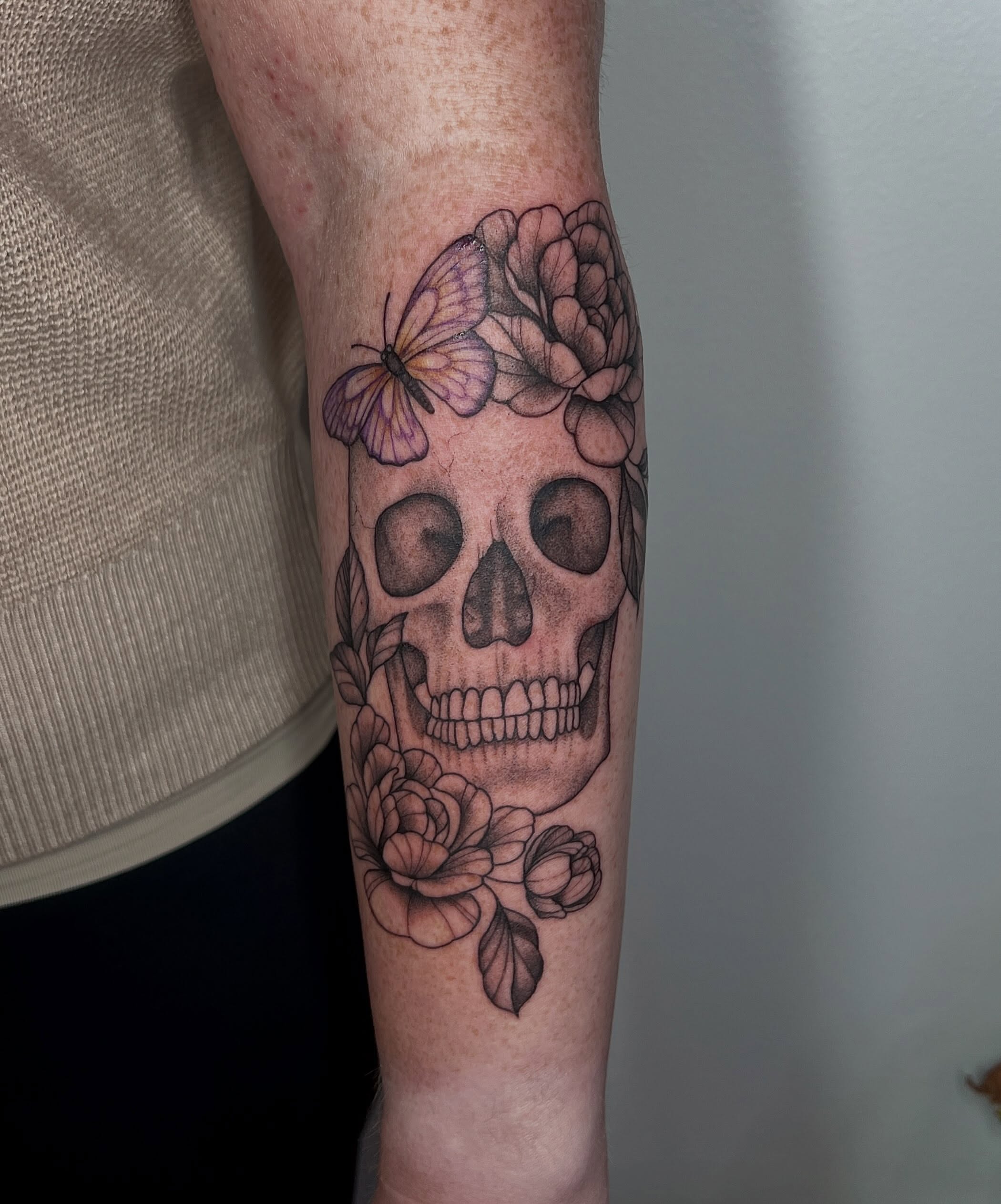 Skull with flowers and butterfly realism tattoo on the forearm by Presley Tattoos, Murfreesboro, Tennessee