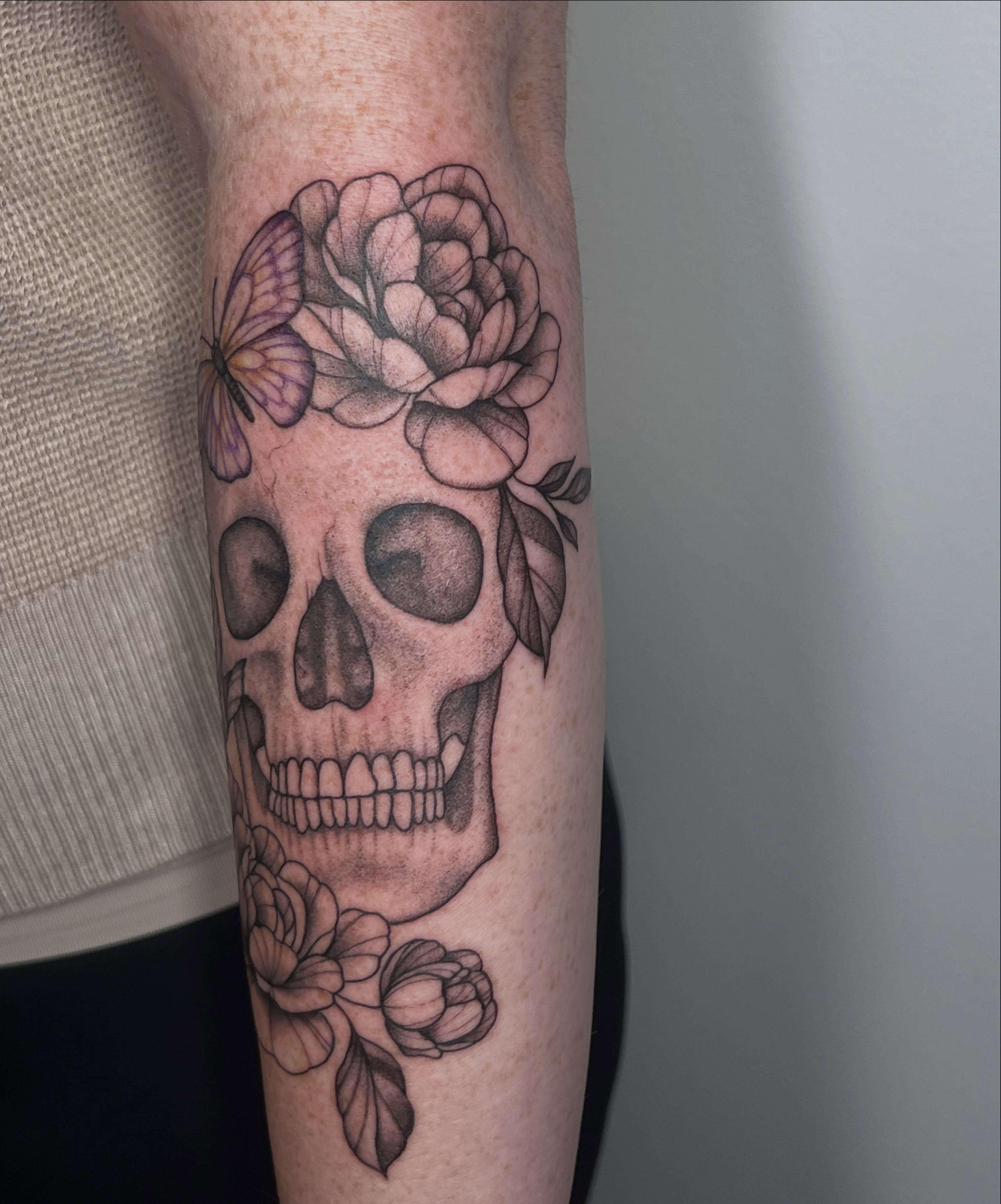 Skull with flowers realism tattoo on the forearm by Presley Tattoos, Murfreesboro, Tennessee