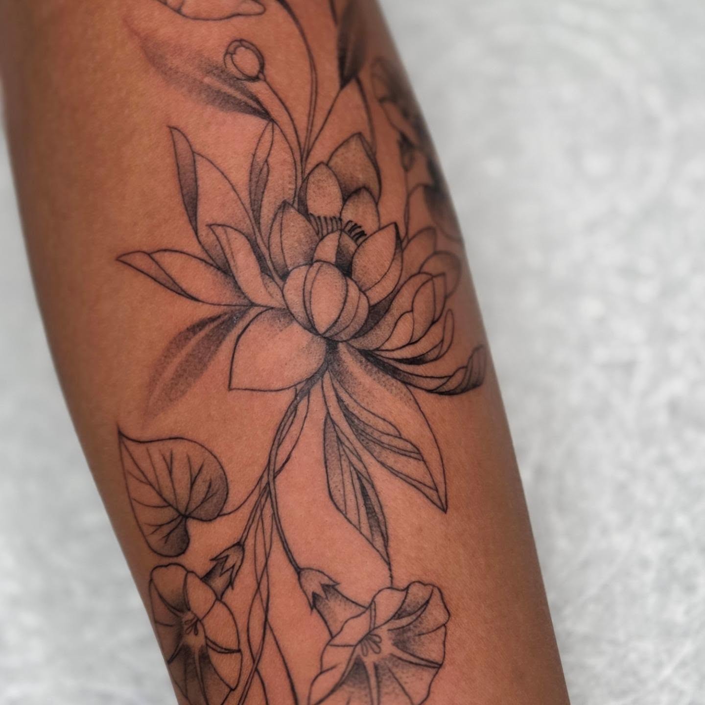 Lotus flower black and grey tattoo on the forearm by Yvette Cebreros