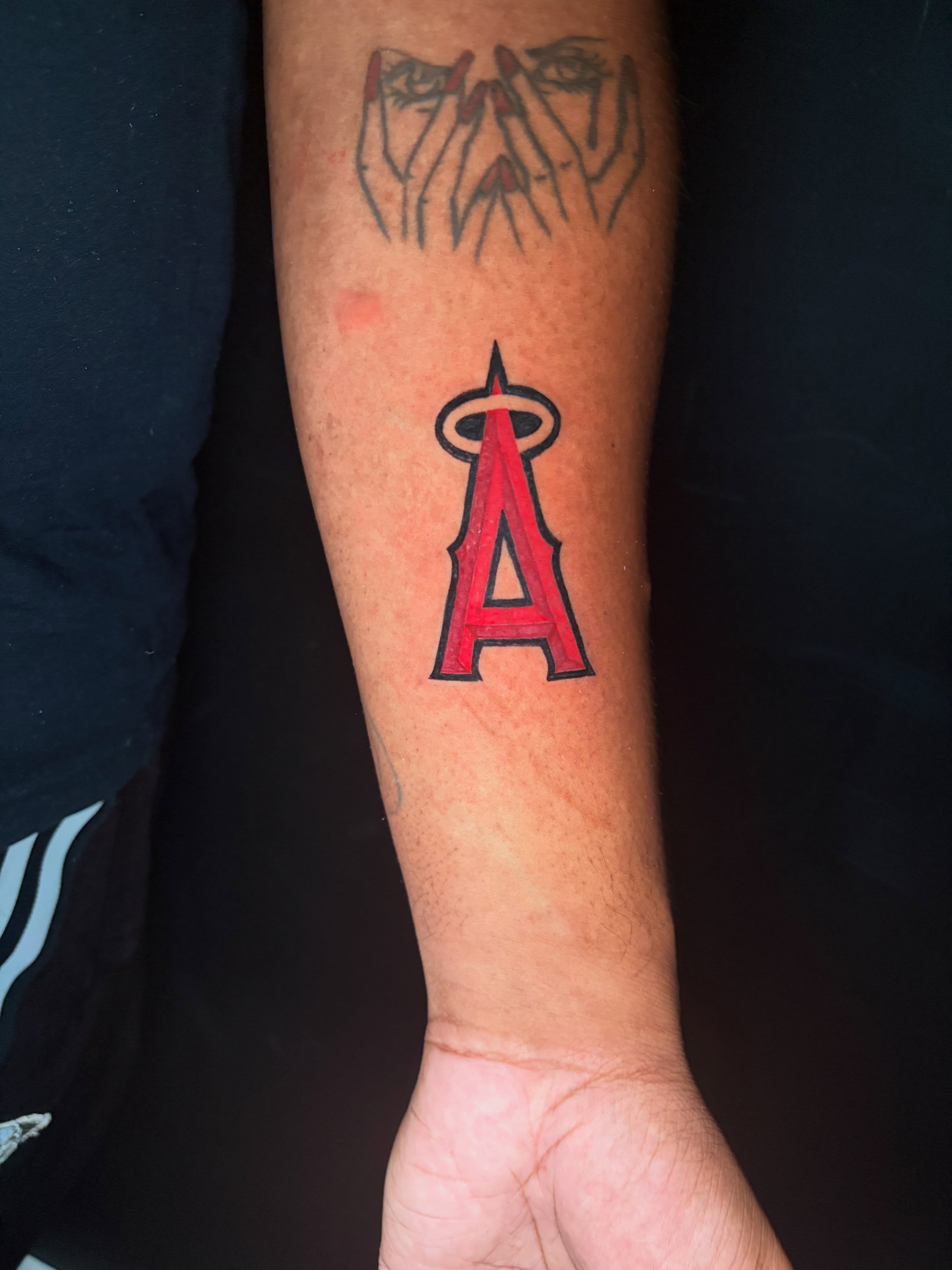 Angels logo American traditional tattoo on the forearm by @getmoneetattz