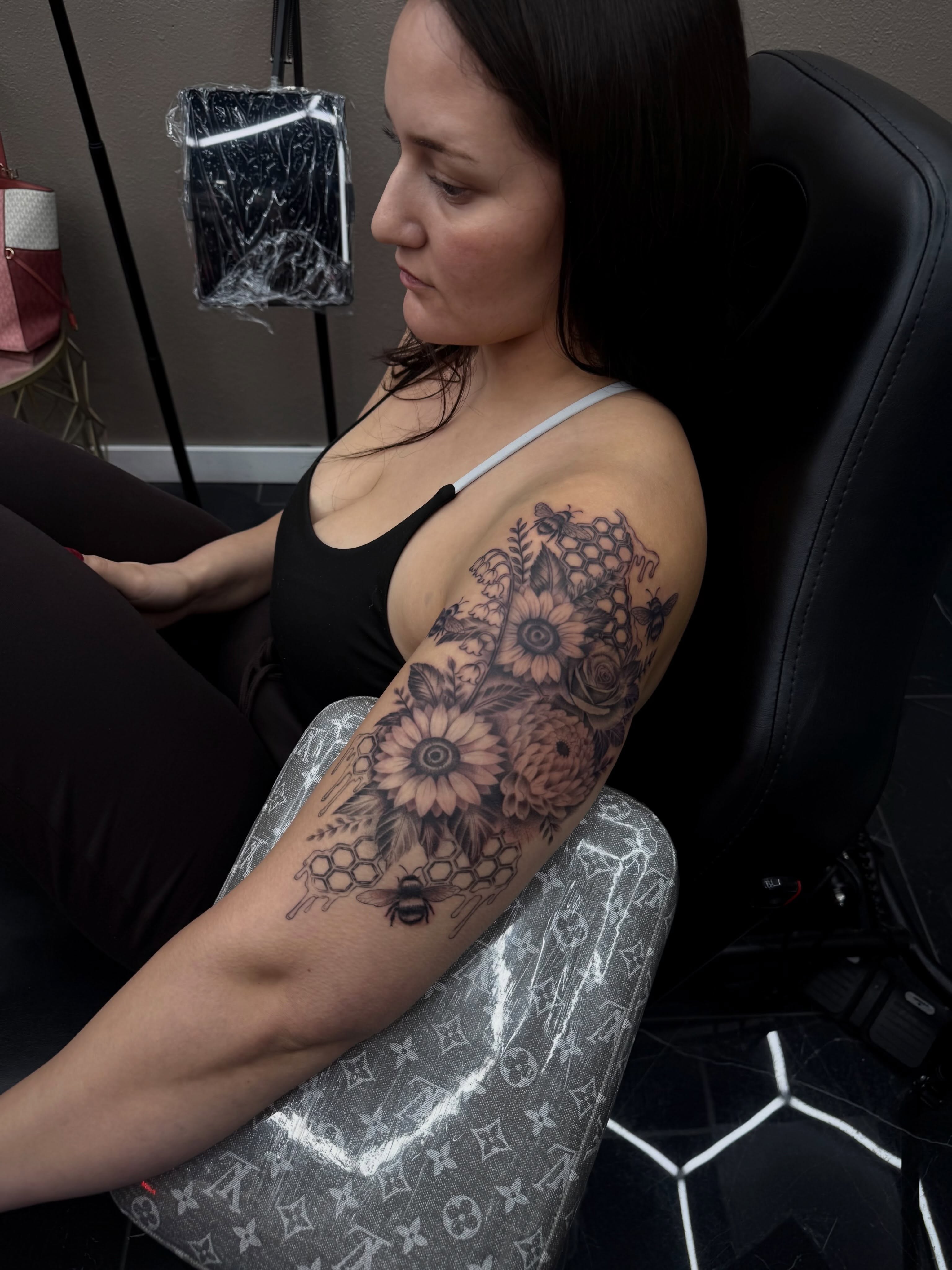 Flowers and bees black and grey tattoo on the forearm by Amber Lynn