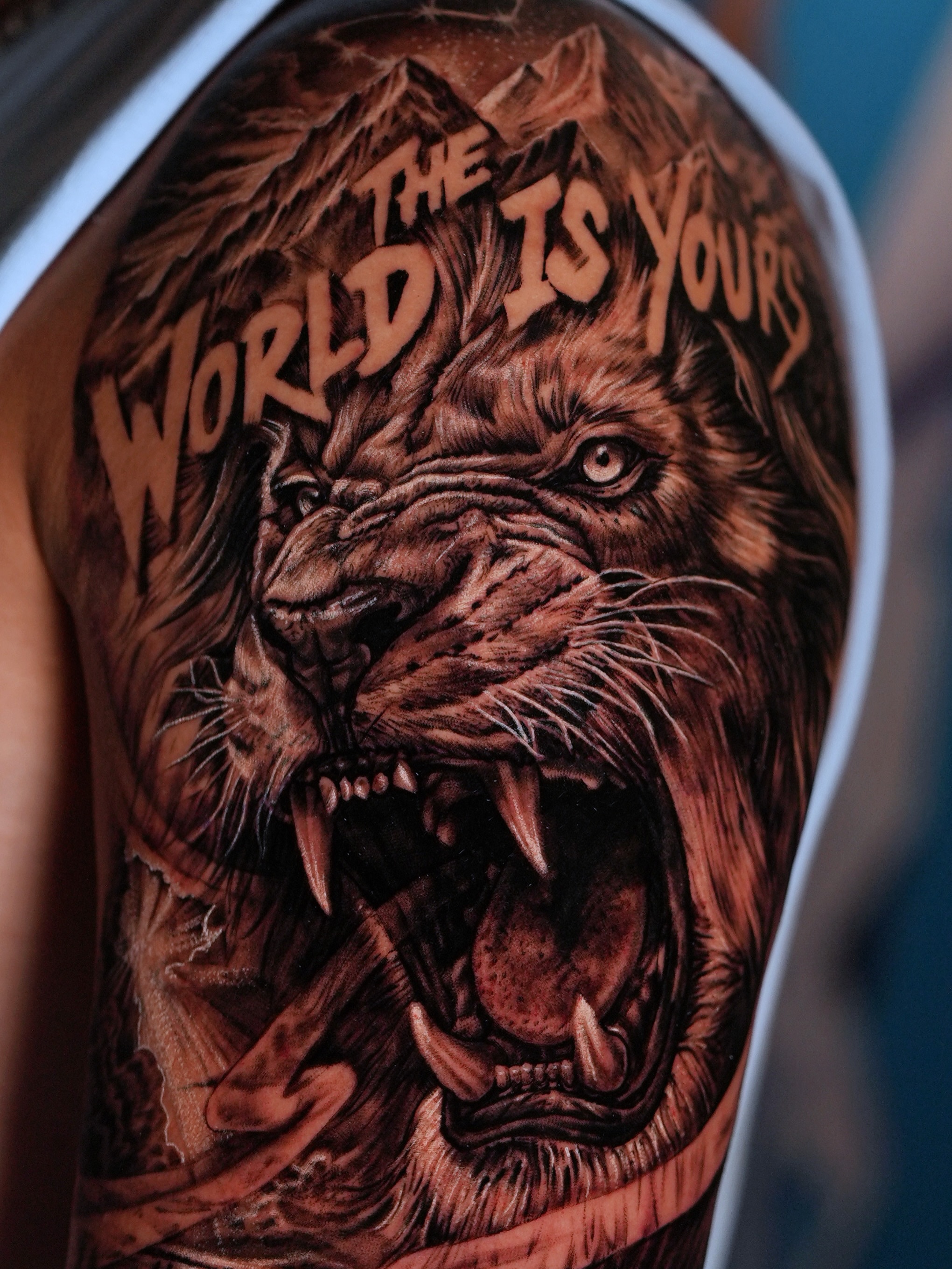 Roaring lion realism tattoo on the upper arm by Alberto M
