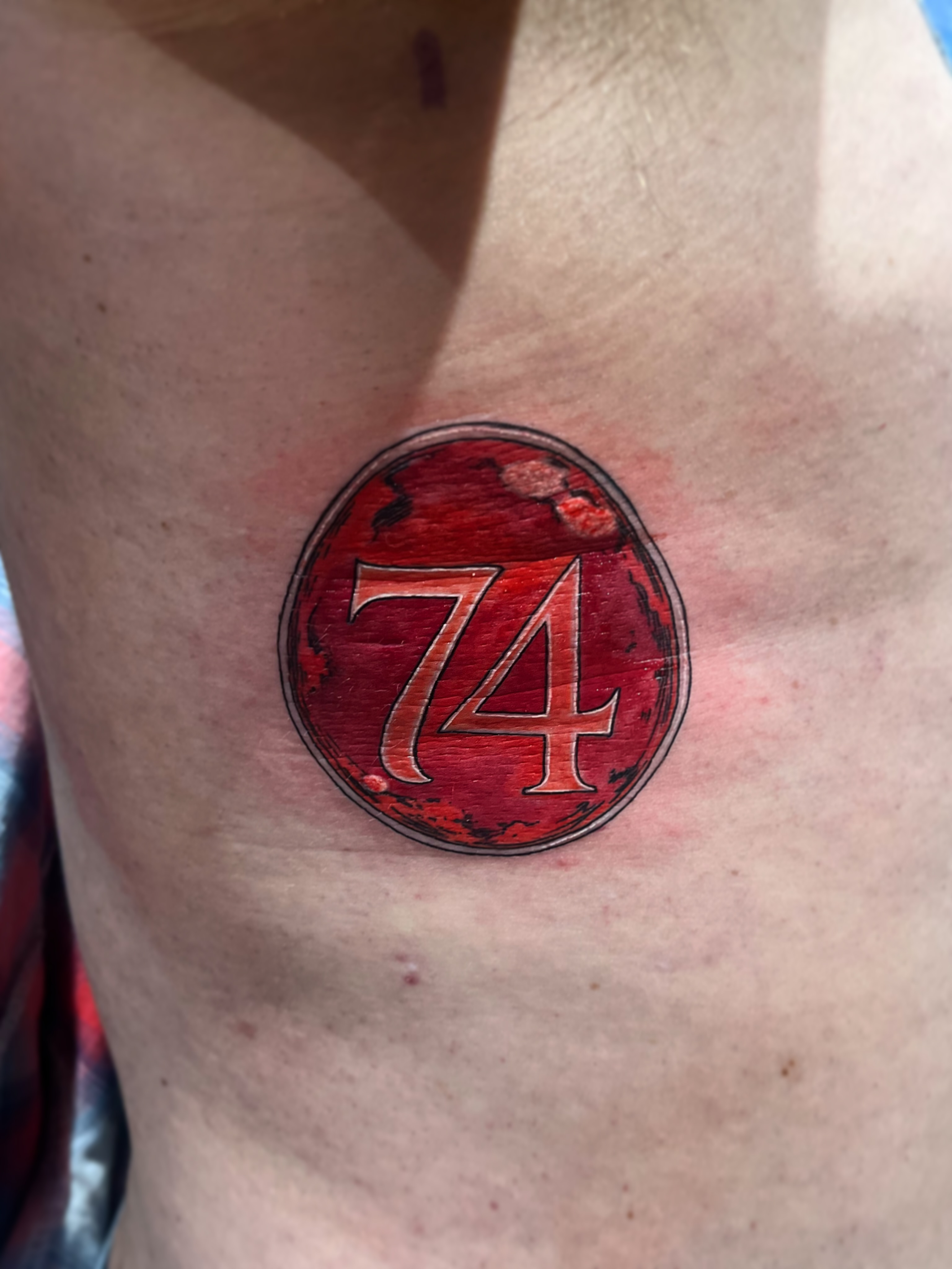 Number 74 dotwork tattoo on the chest by Elle Miller