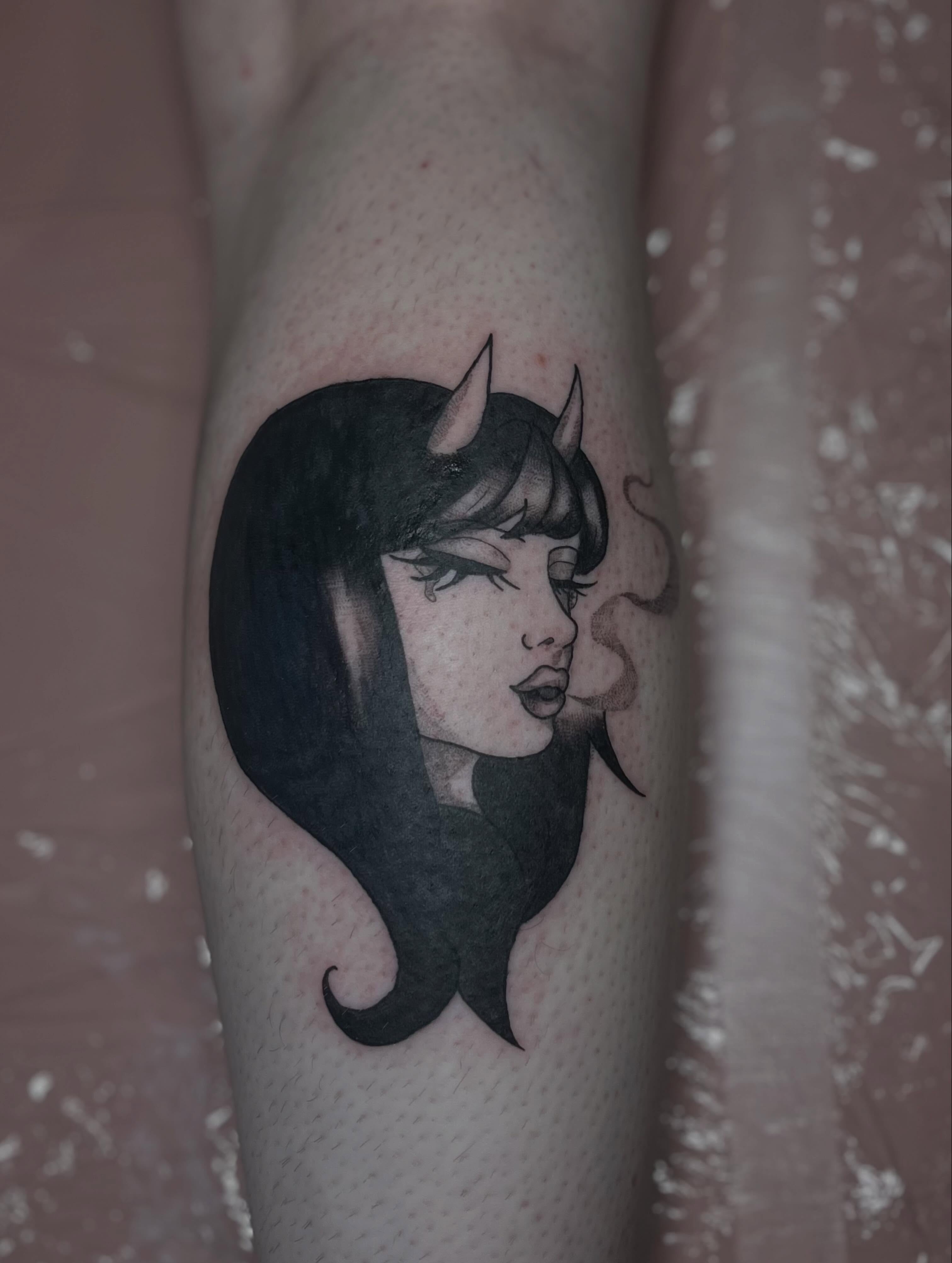Woman with horns black and grey tattoo on the forearm by Jazzy