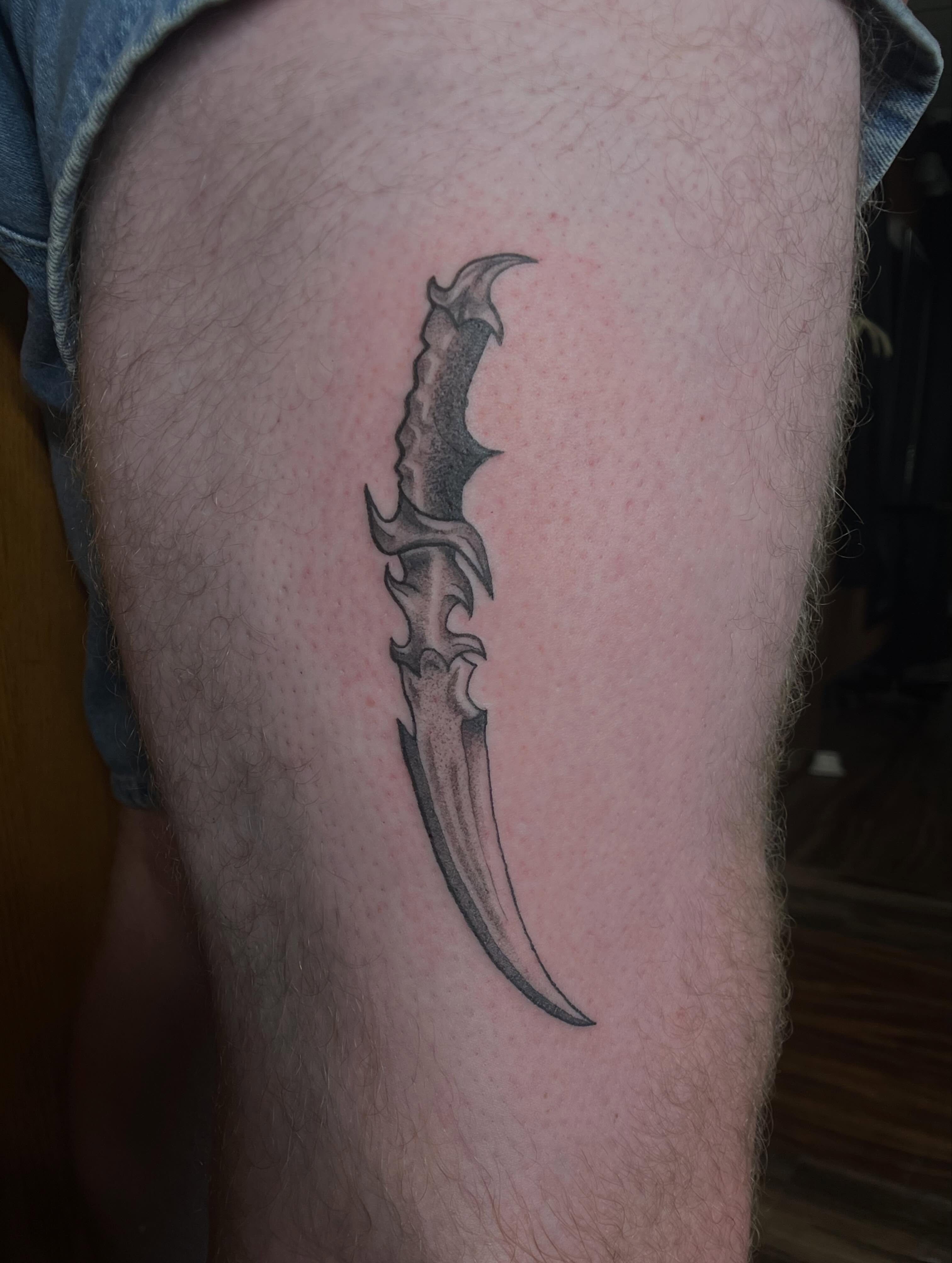 Knife black and grey tattoo on the leg by Jazzy