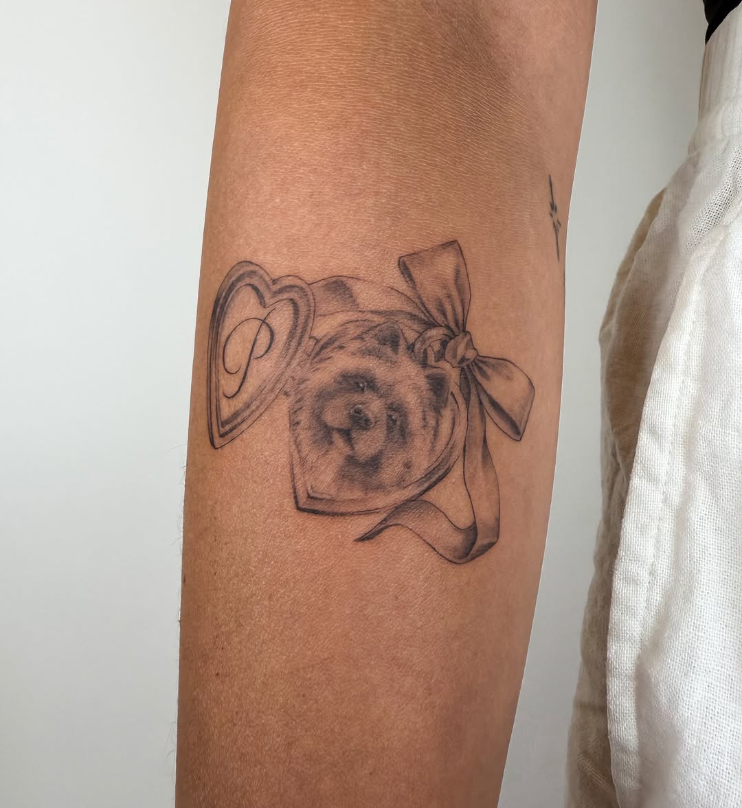 Dog portrait with heart locket realism tattoo on the forearm by Helly March