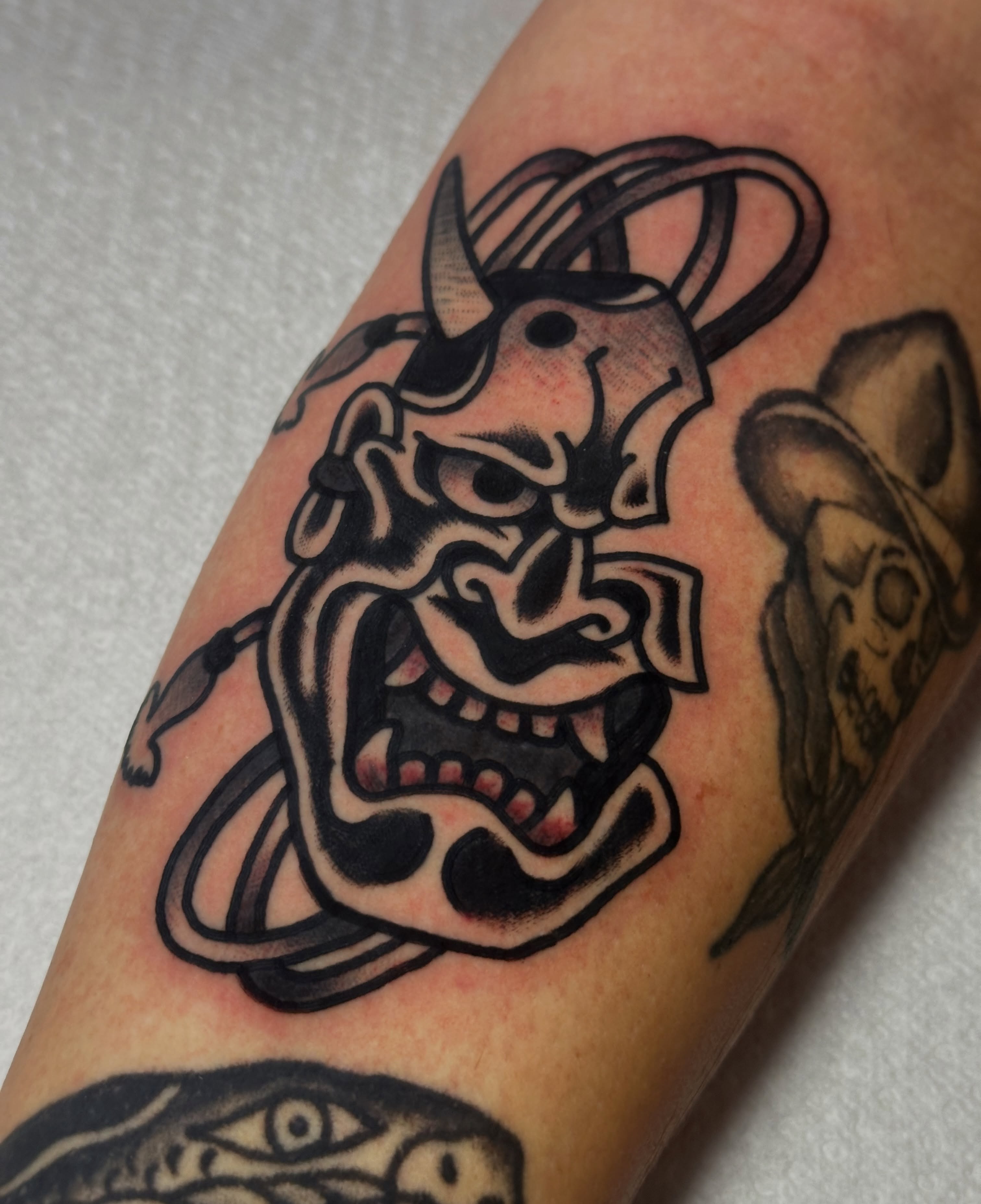 Demon mask American traditional tattoo on the forearm by Christian Rieben