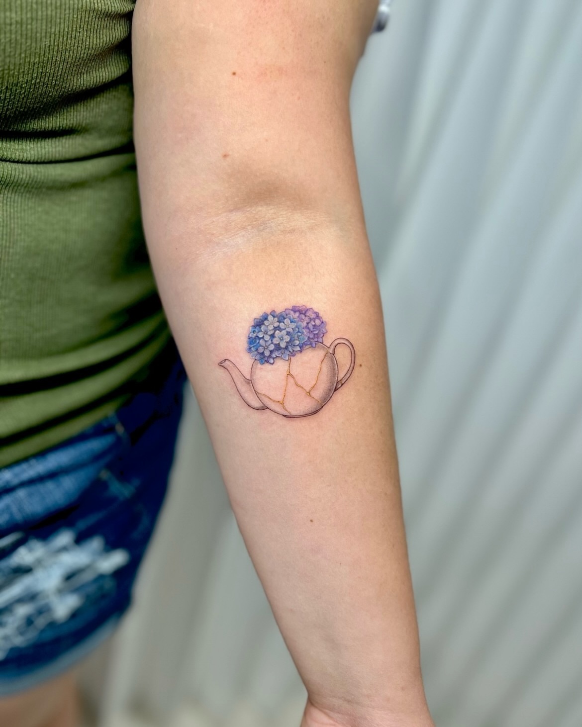Teapot with flowers watercolor tattoo on the forearm by Soy 🫛