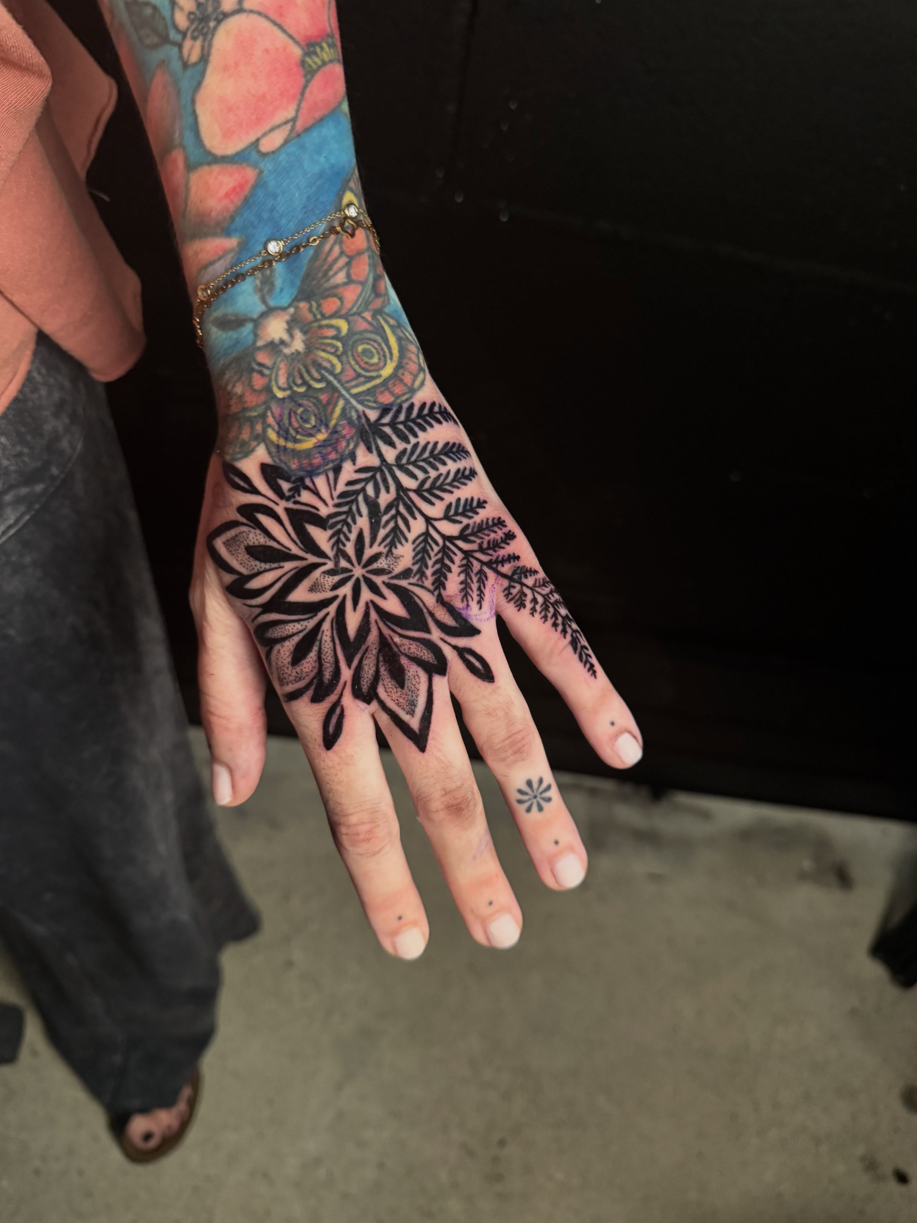 Floral design black and grey tattoo on the hand by Brandiane Wells
