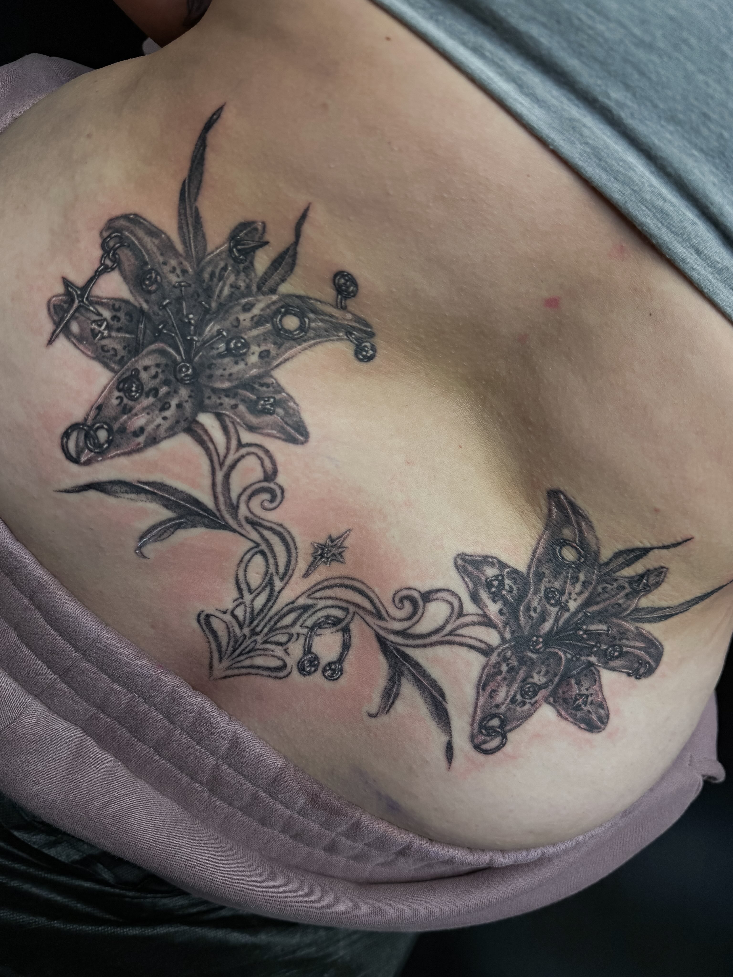 Lilies black and grey tattoo on the ribs by Yvonne