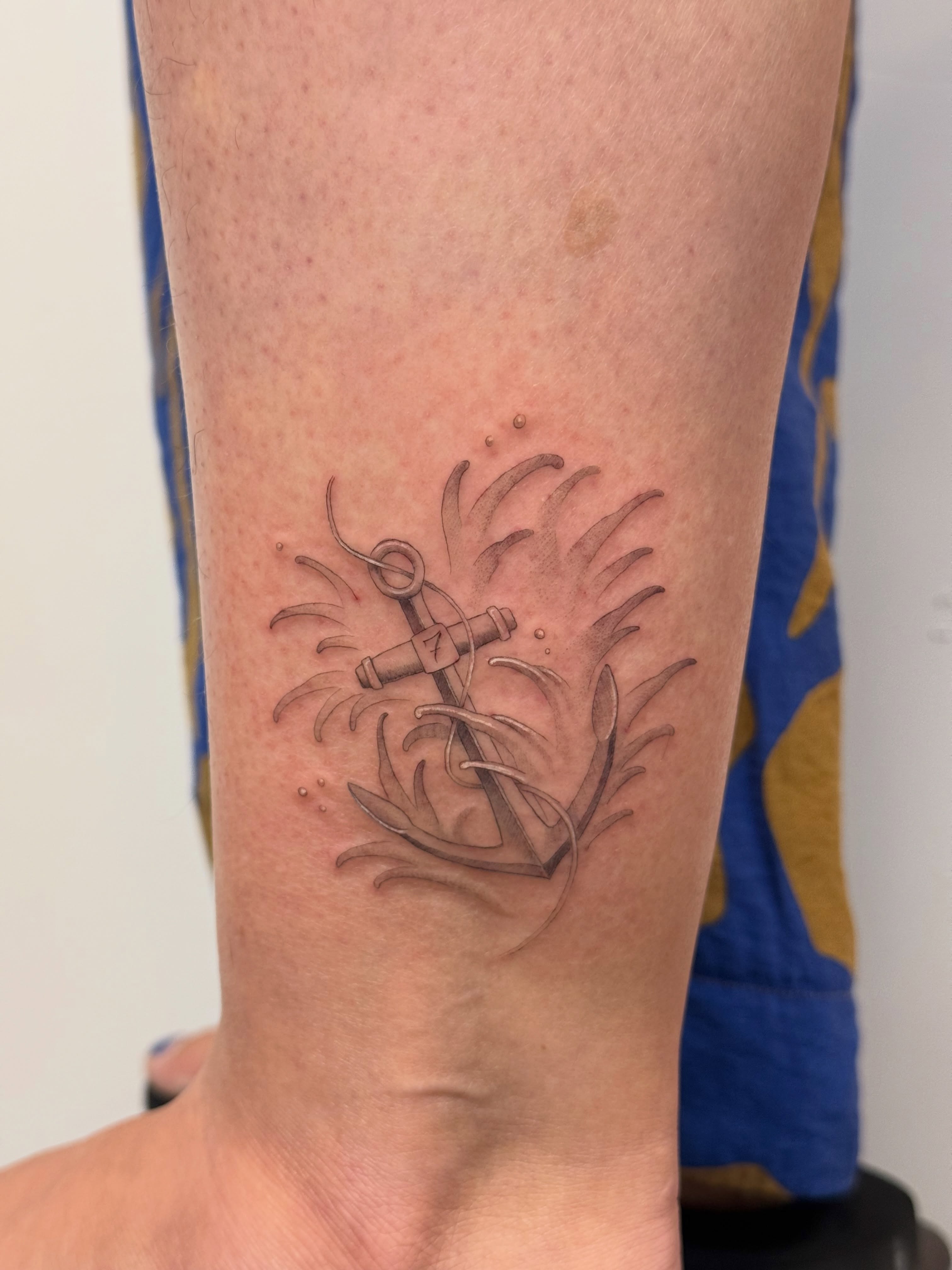 Anchor and leaves black and grey tattoo on the forearm by Justin Turkus
