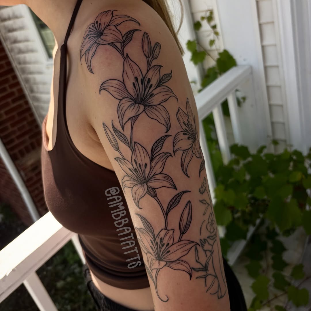 Lilies black and grey tattoo on the upper arm by amber brady, Brunswick, Ohio