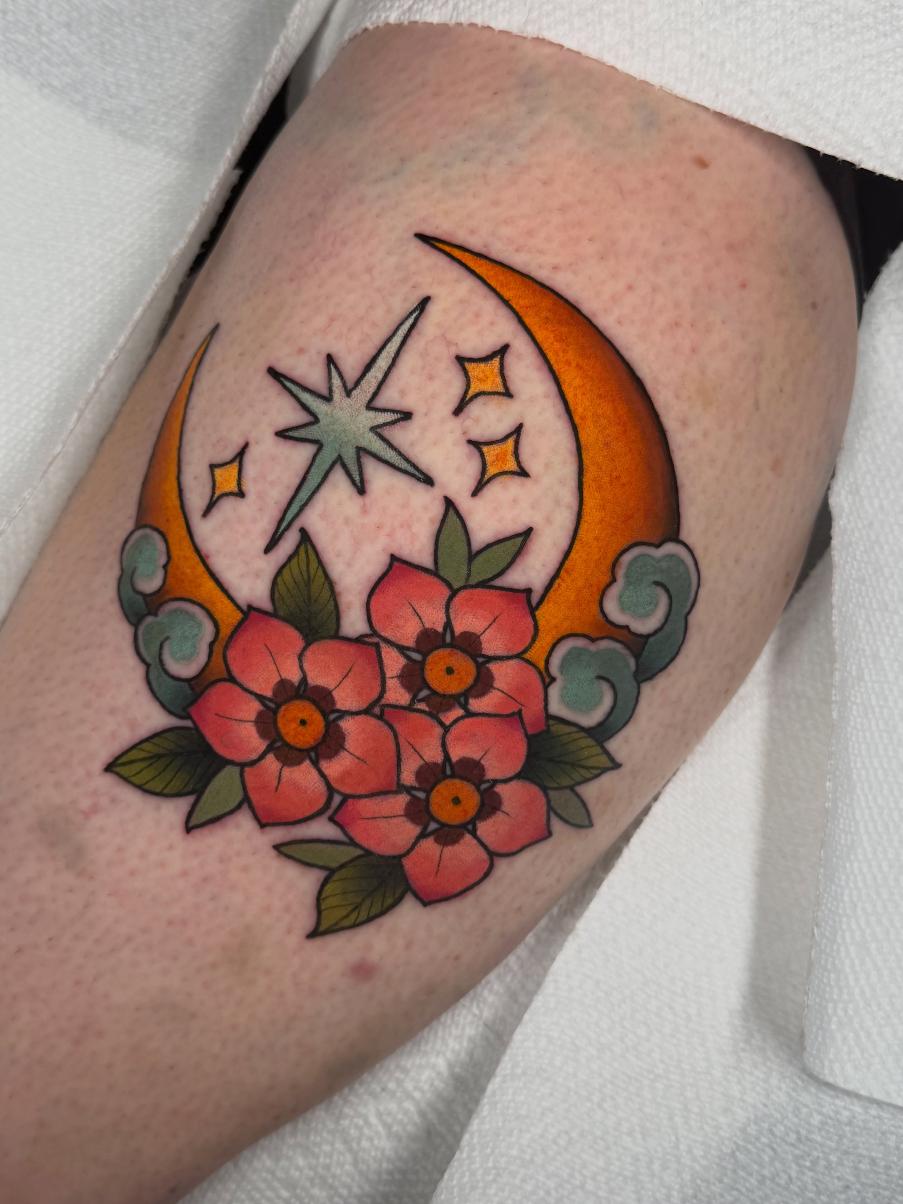 Moon, stars, flowers American traditional tattoo on the forearm by Kyle Kuhn