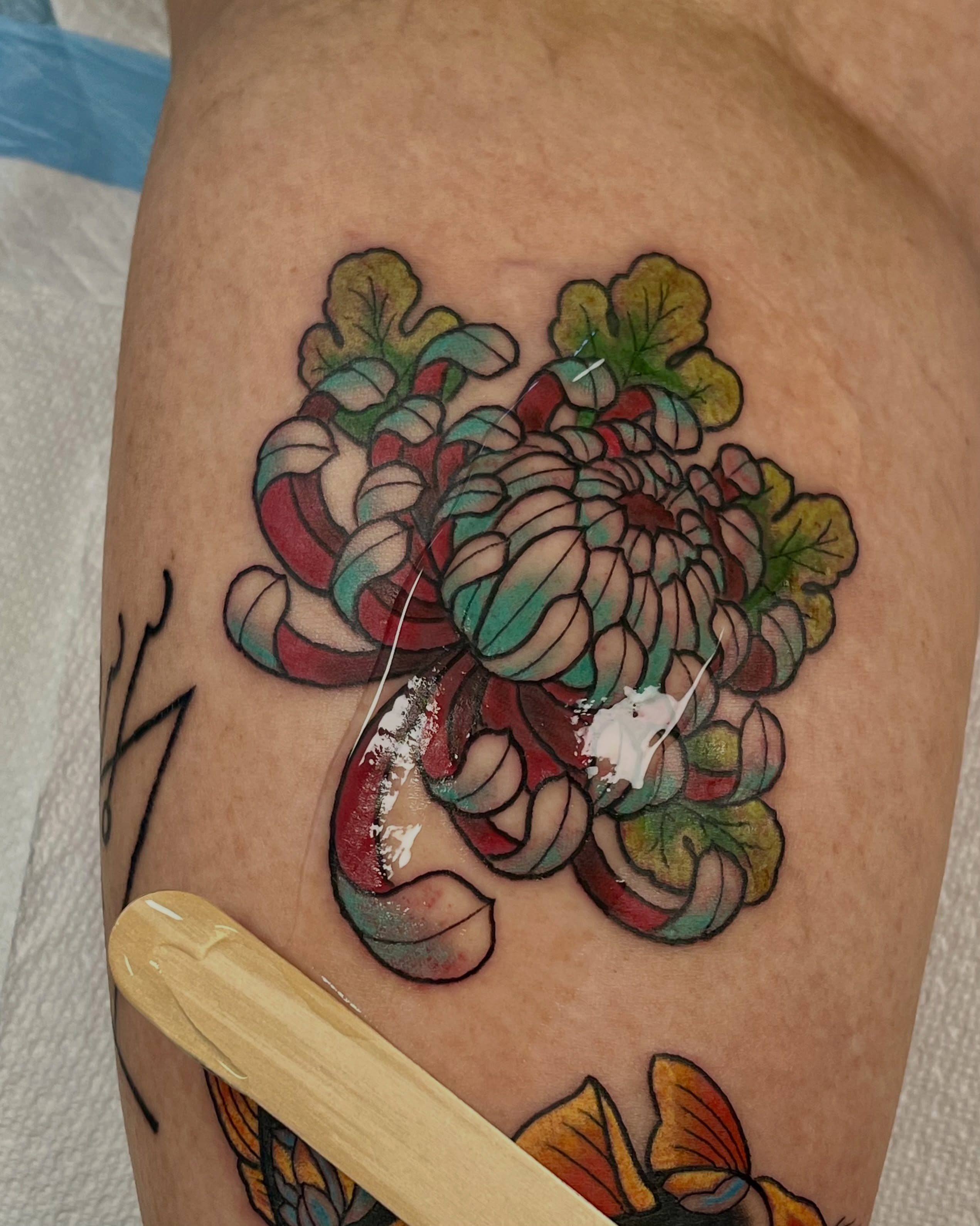Chrysanthemum American traditional tattoo on the thigh by EO, Chicago, Illinois