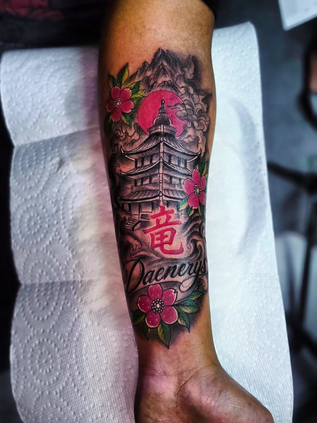 Pagoda, name, and flowers Japanese tattoo on the forearm by Kai_Tattoo