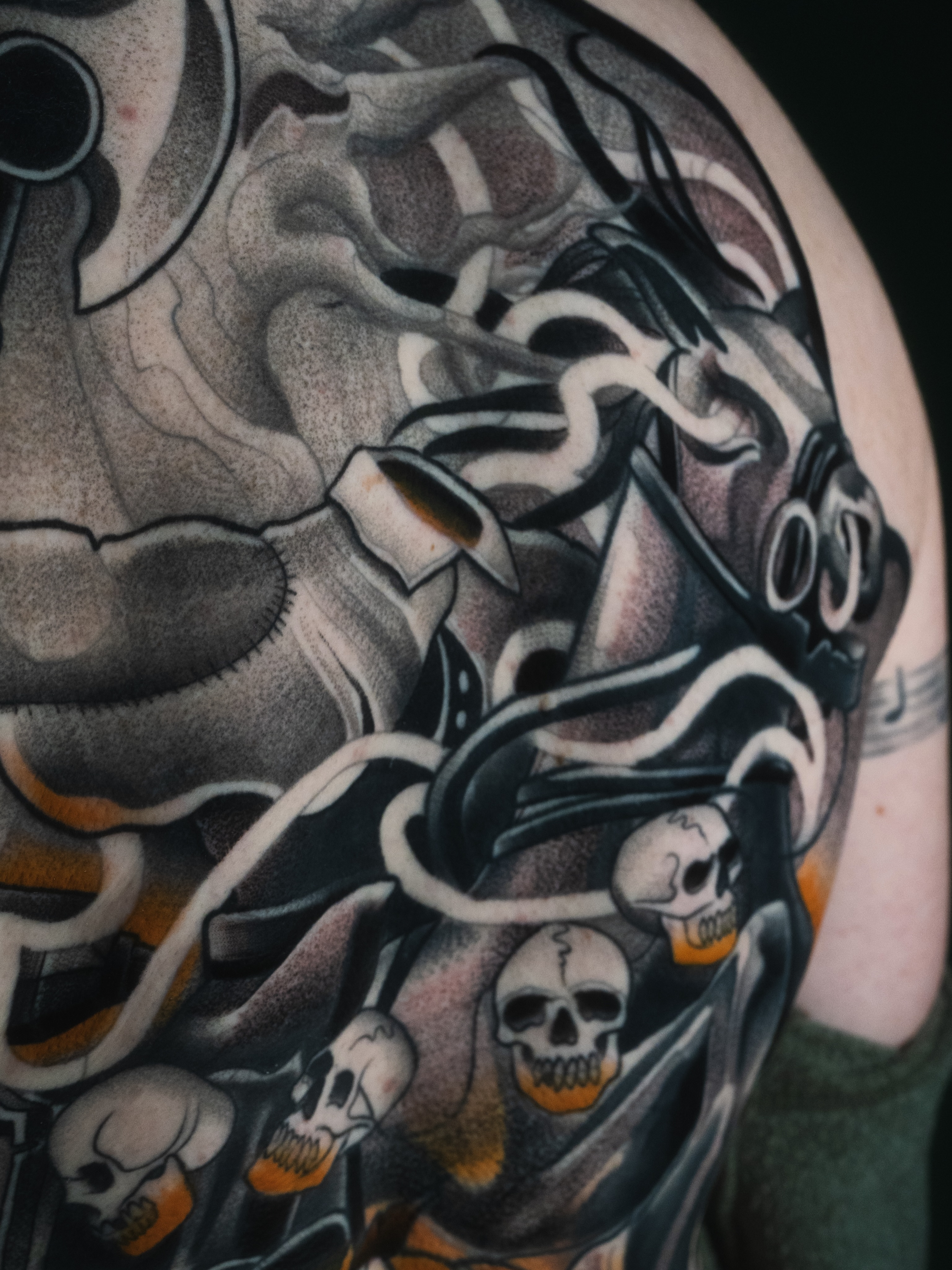 Skulls and serpents dark realism tattoo on the shoulder by Robert Graye