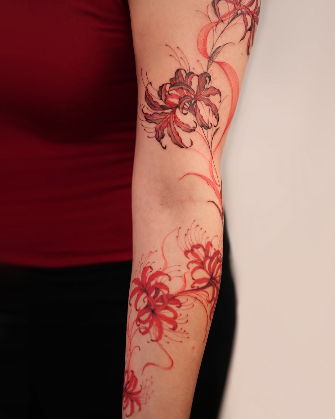 Lilies watercolor tattoo on the forearm by Zalina Loriia