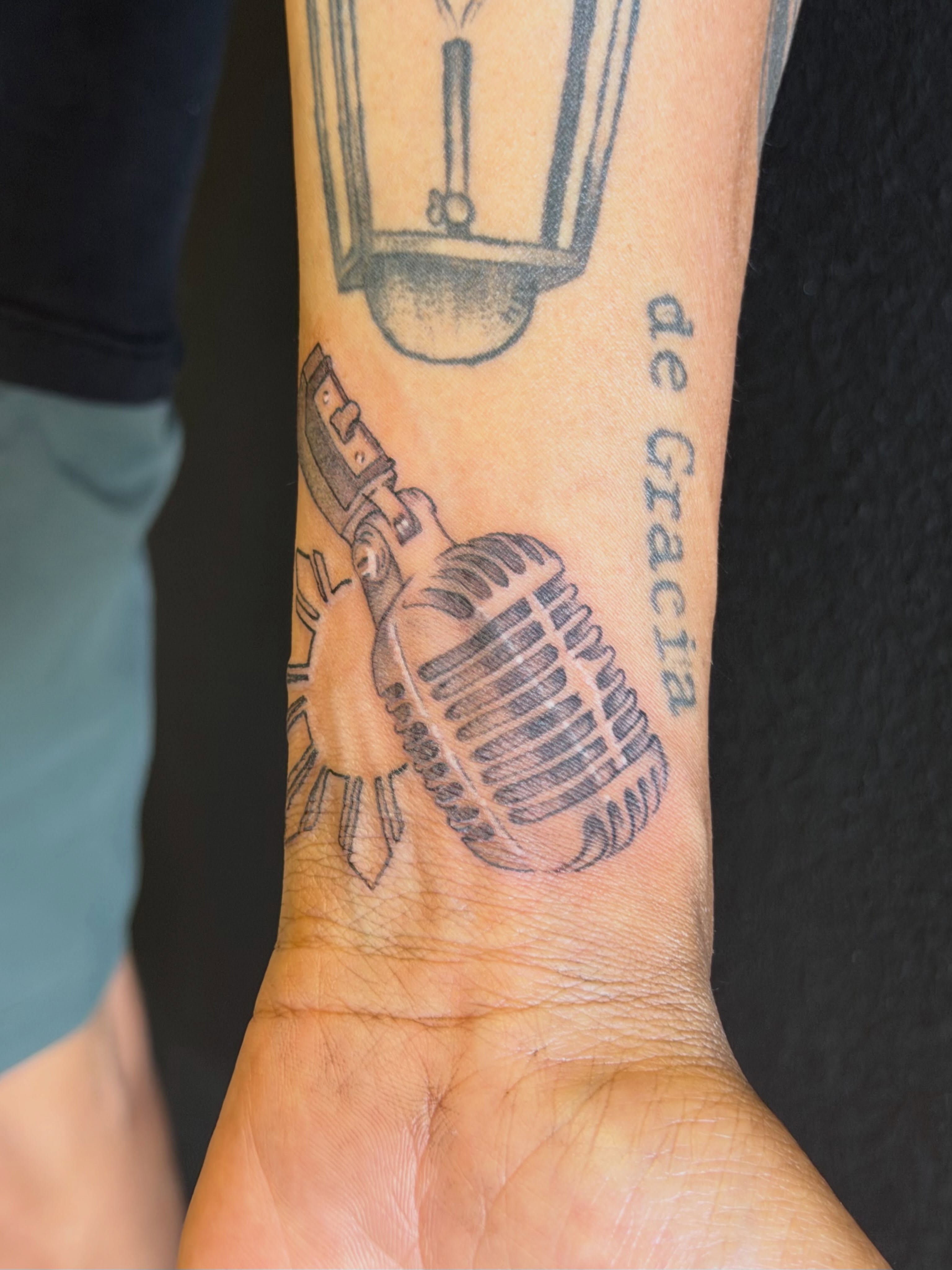 Microphone black and grey tattoo on the forearm by LooSid