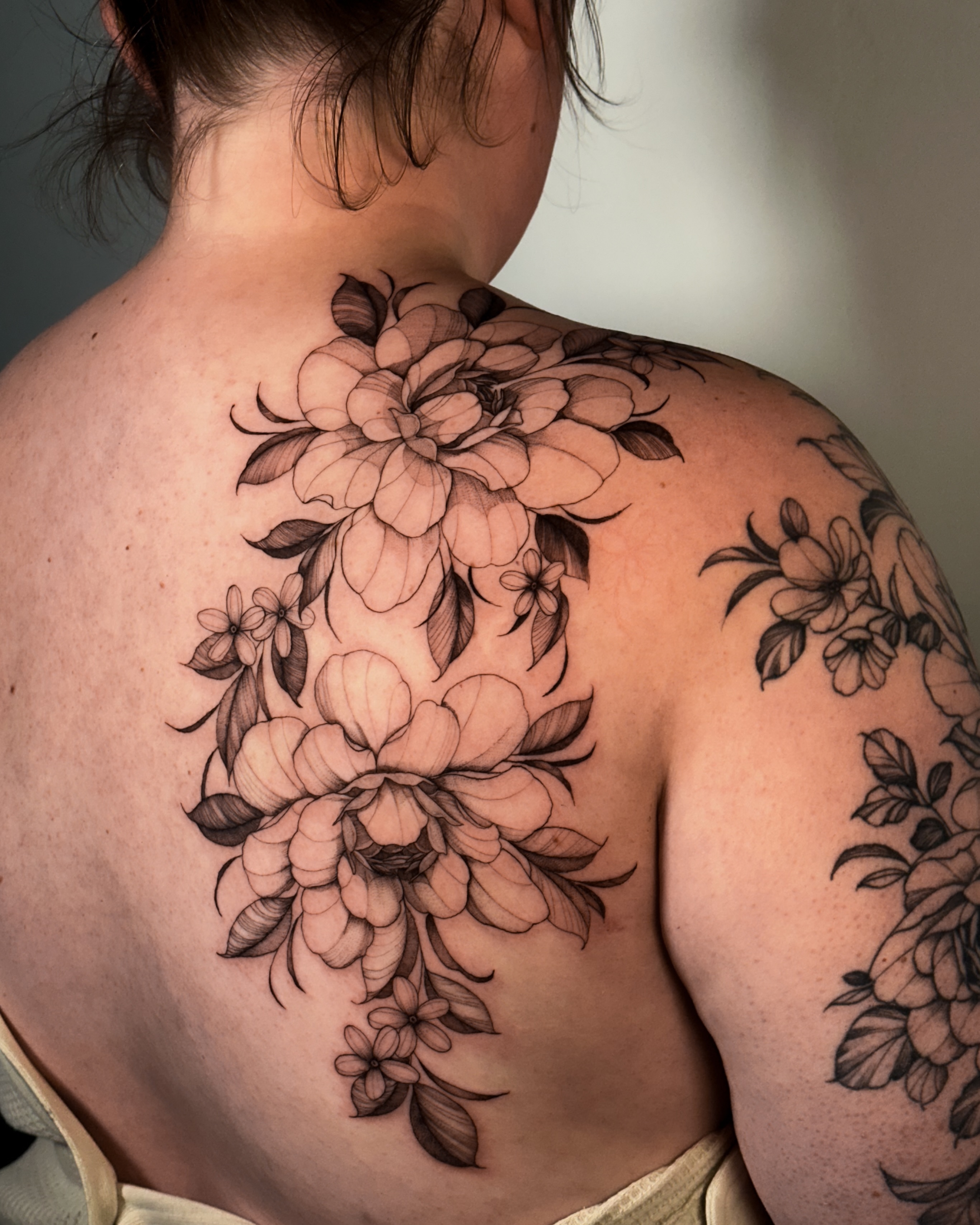 Floral bouquet black and grey tattoo on the back by Caroline + Utah Tattoo Artist