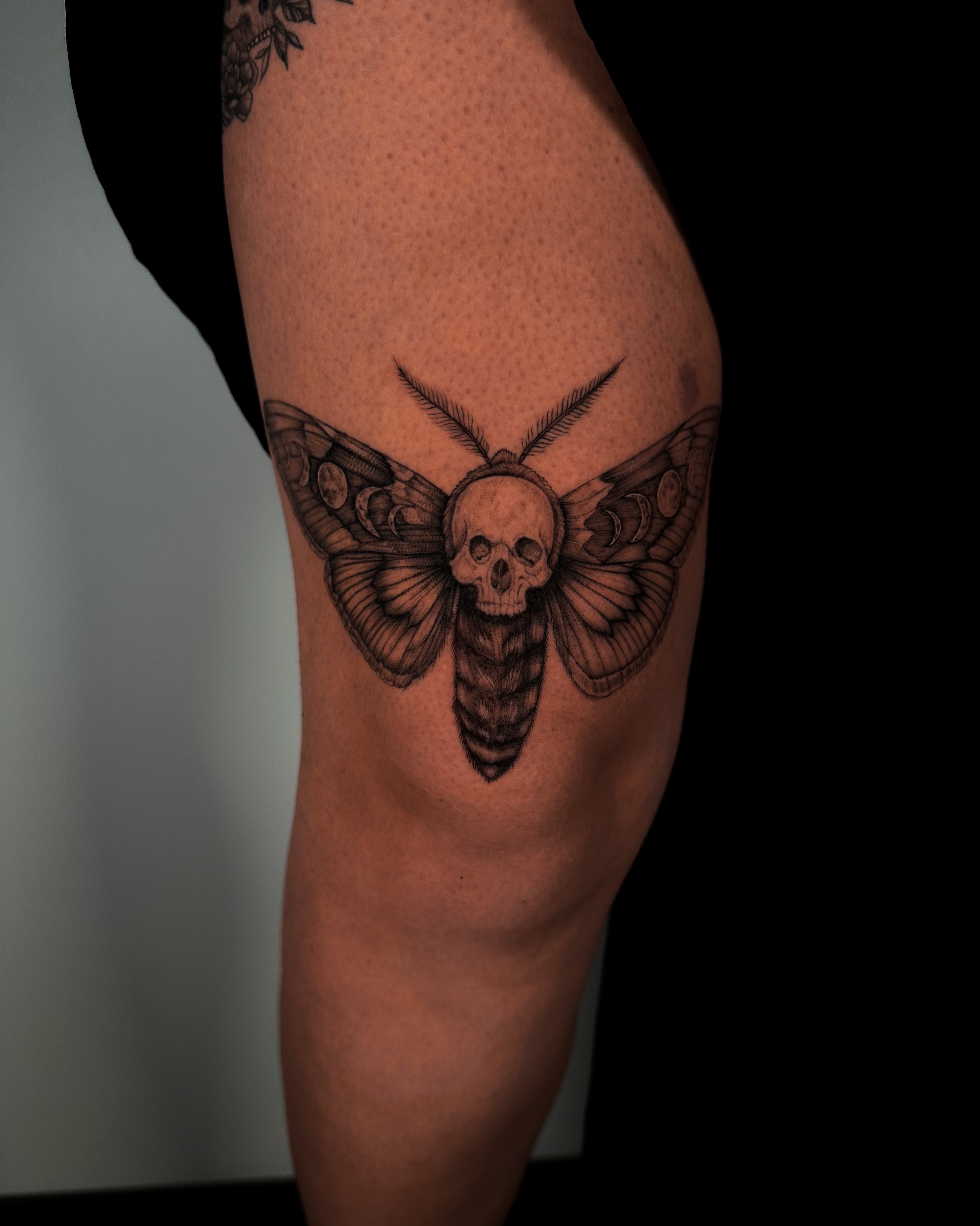 Moth skull black and grey tattoo on the thigh by Caroline + Utah Tattoo Artist