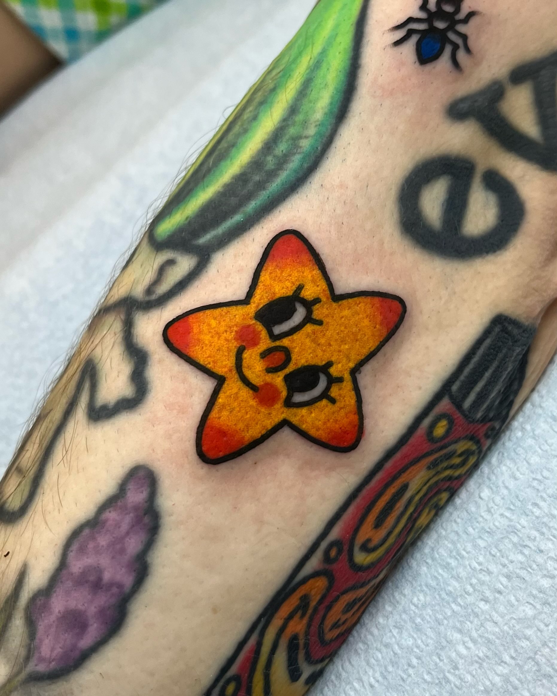 Starfish new school tattoo on the forearm by Em Adkins