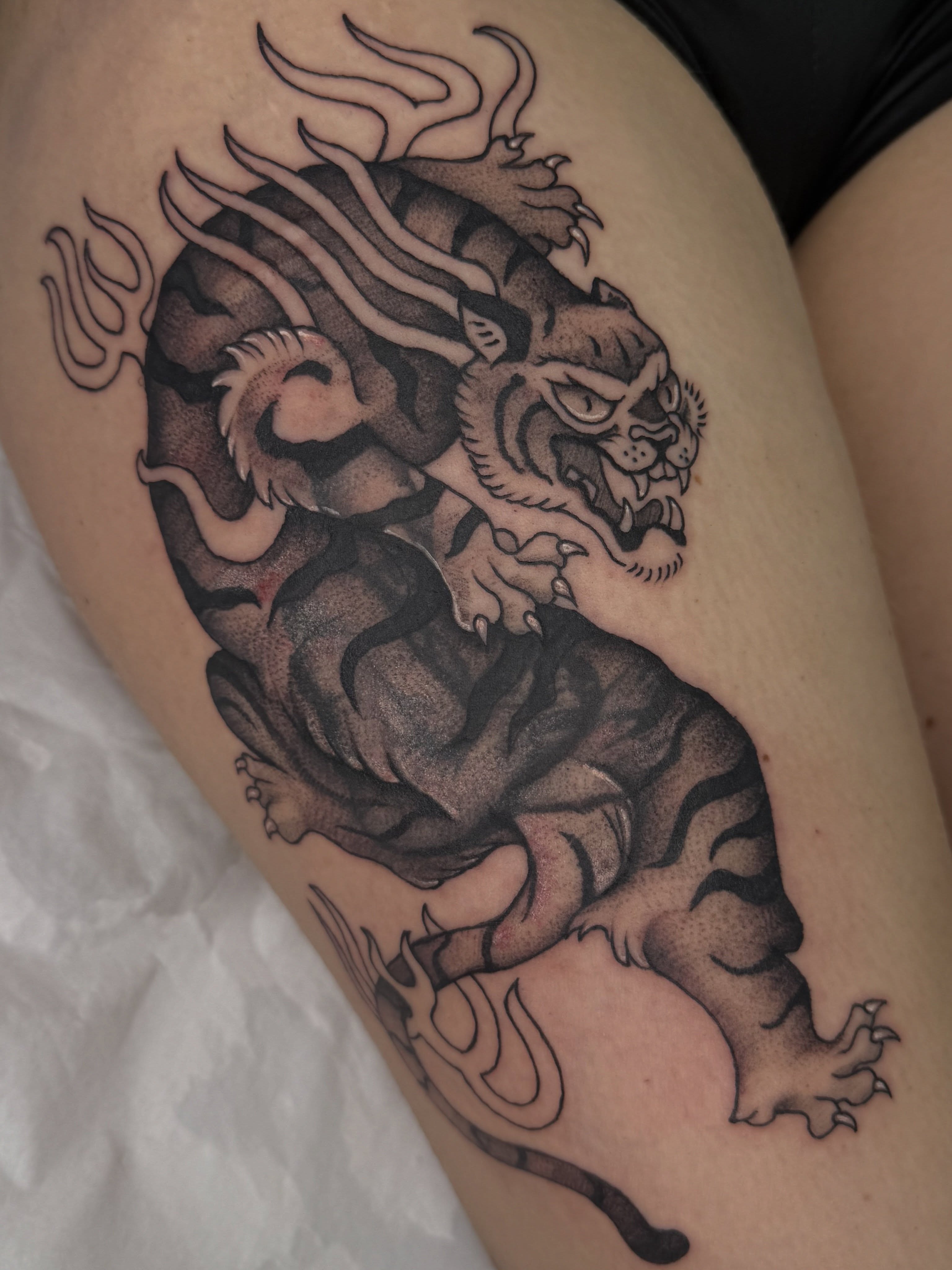 Lion black and grey tattoo on the thigh by Halle Cooper