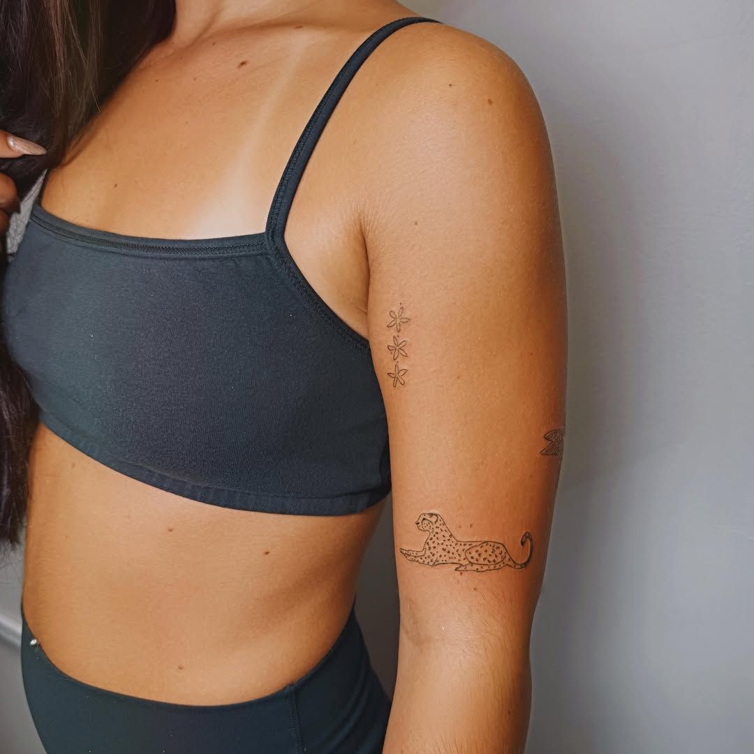 Cheetah black and grey tattoo on the forearm by Ashlee Burkey