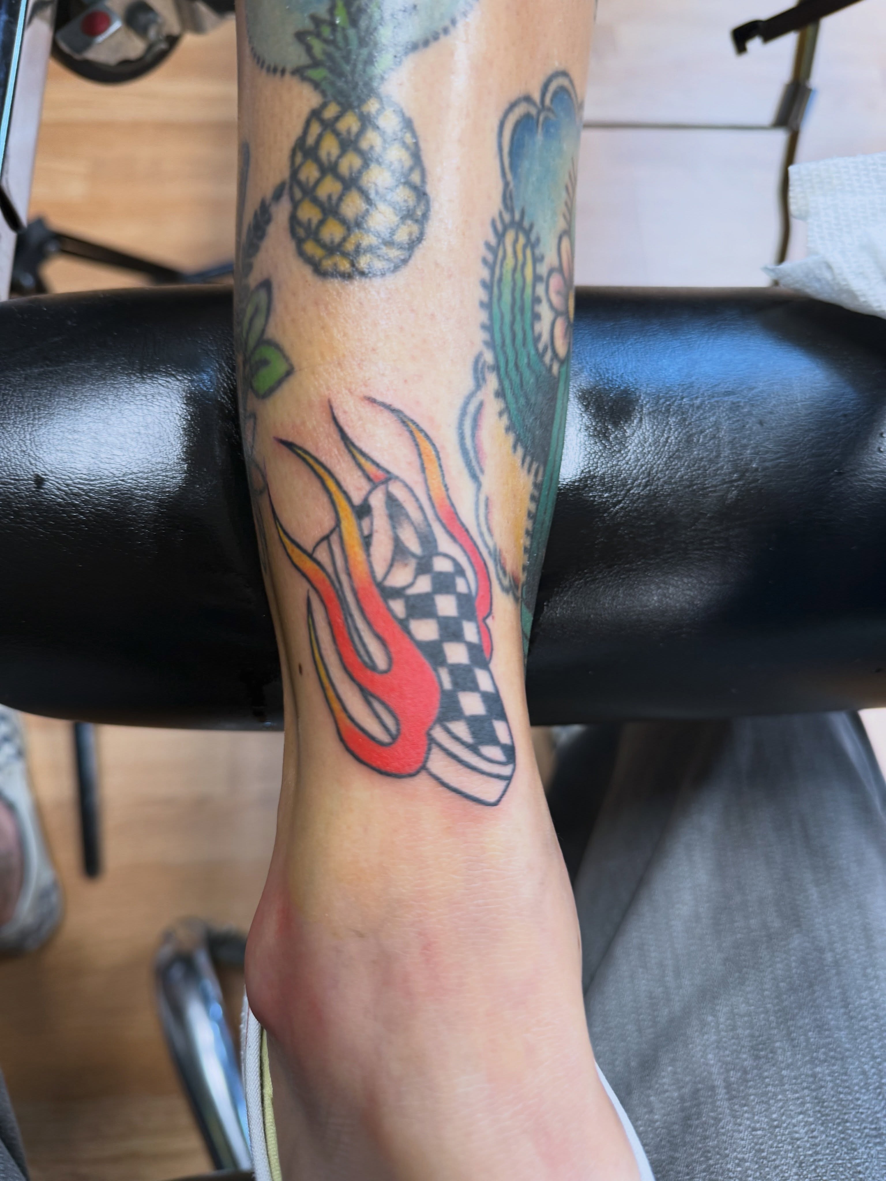 Flame and checkered shoe American traditional tattoo on the forearm by Palmer Andrist🩸Fort Collins Tattoo Apprentice