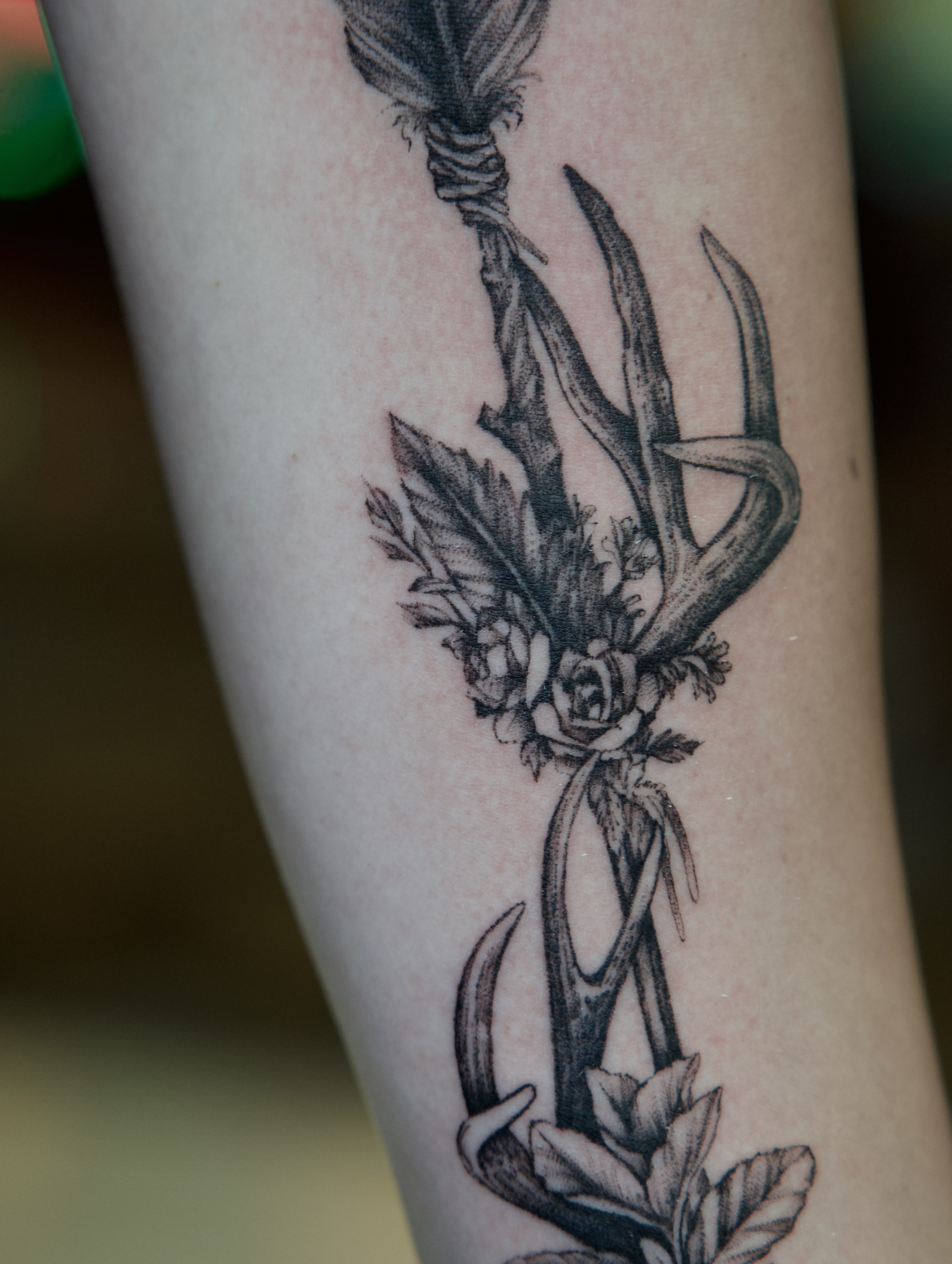 Antlers and flowers black and grey tattoo on the forearm by Raven Wood